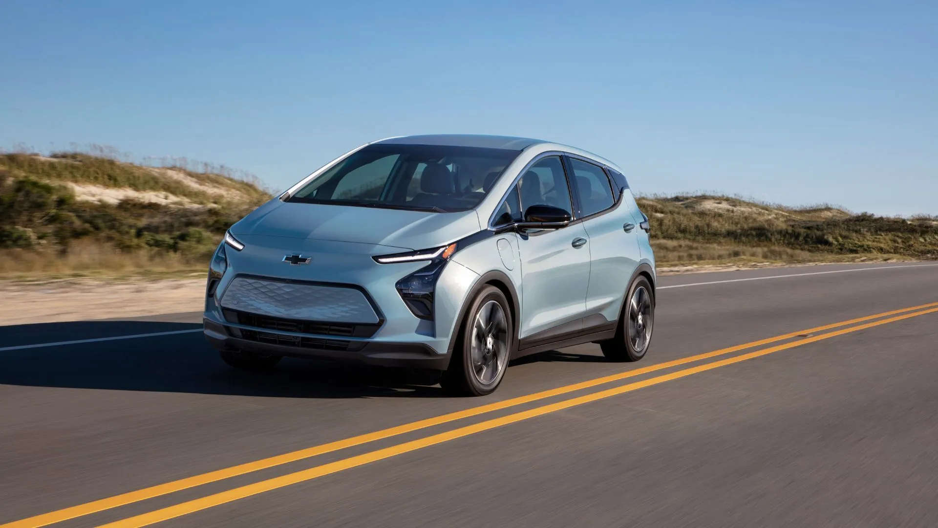 Góc 3/4 phía trước động học của một chiếc Chevrolet Bolt EV 2022 màu bạc đang lái trên đường nông thôn.