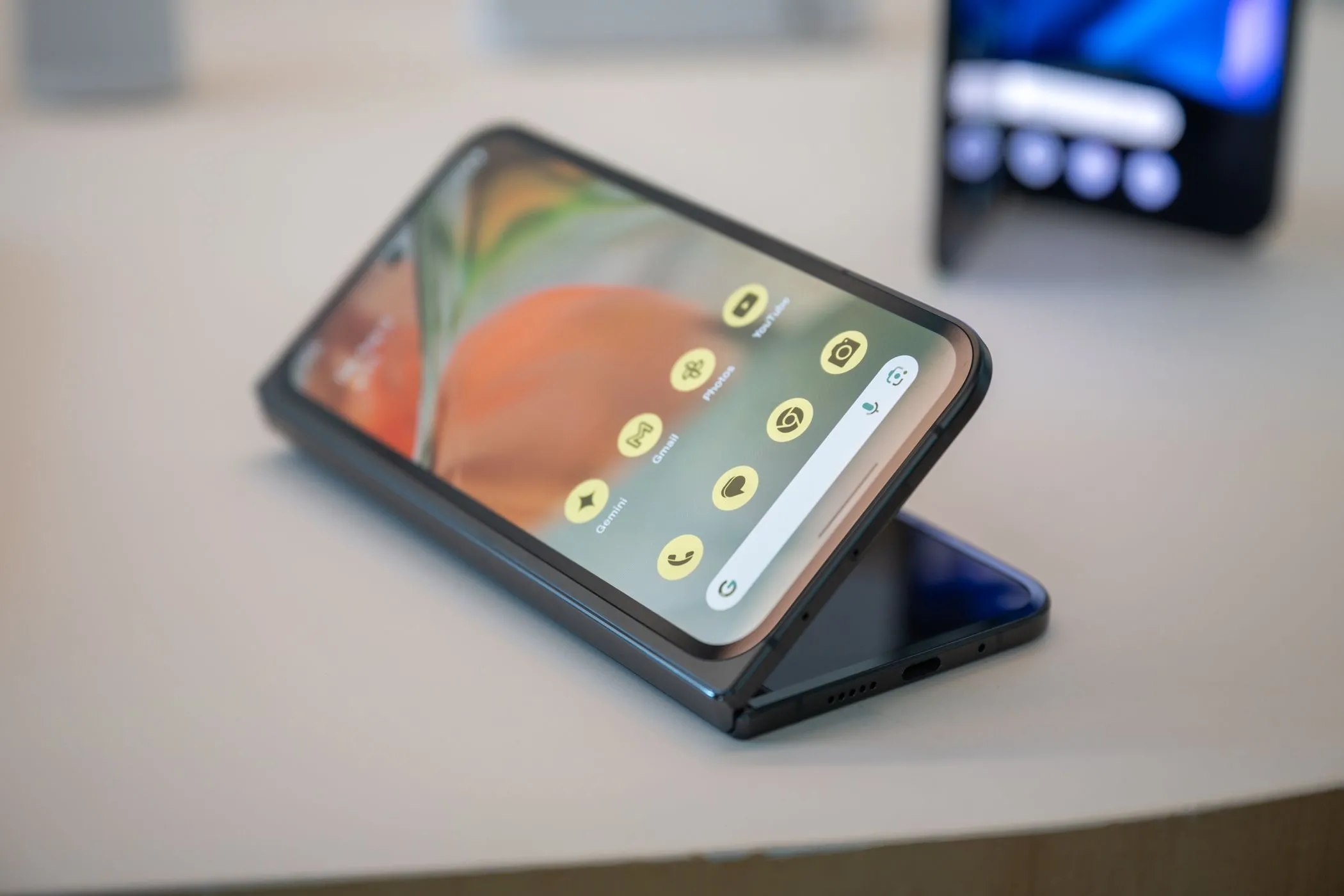 Google Pixel 9 Pro Fold đang nằm trên bàn với màn hình gập mở nhẹ, thể hiện thiết kế và kích thước màn hình lớn.