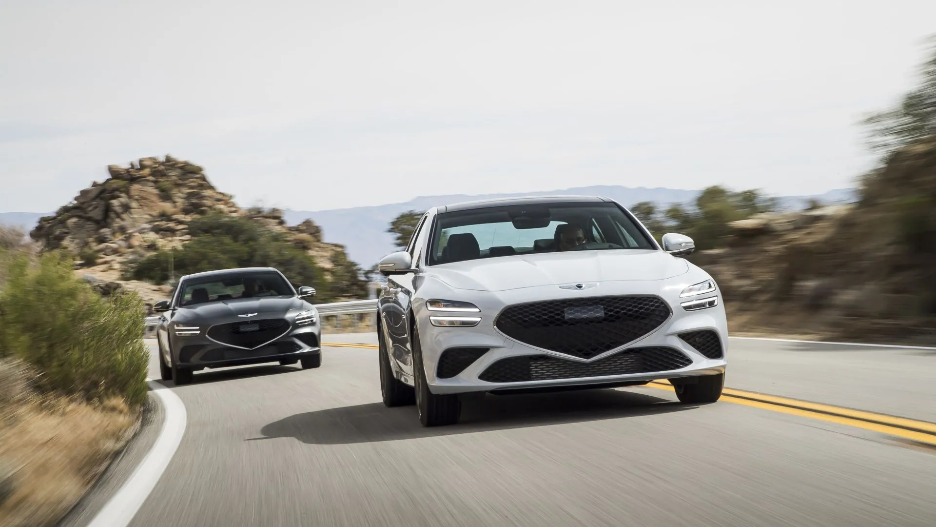Hai chiếc Genesis G70 2025 với thiết kế đèn pha đặc trưng và lưới tản nhiệt cỡ lớn