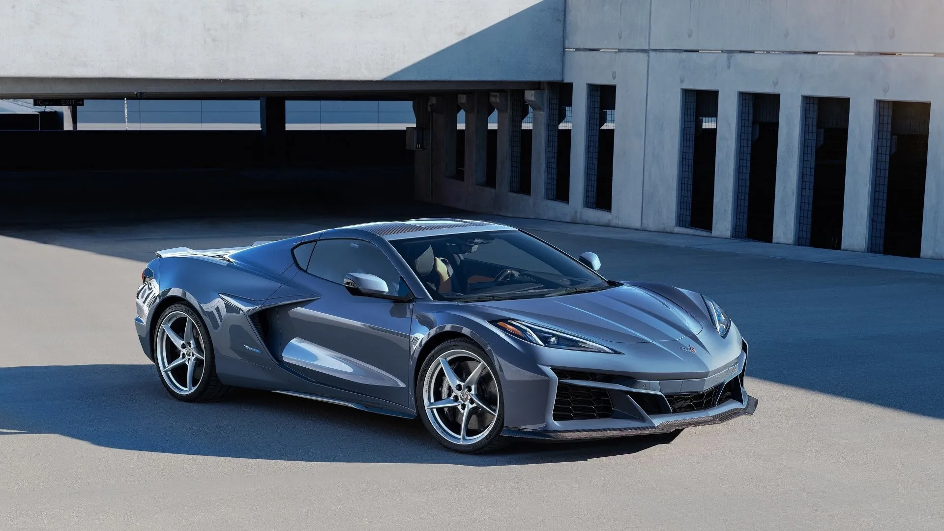 Hình ảnh cận cảnh Chevrolet Corvette E-Ray 2024 màu đen với đèn pha sáng rực, biểu tượng cho xe thể thao hiệu suất cao