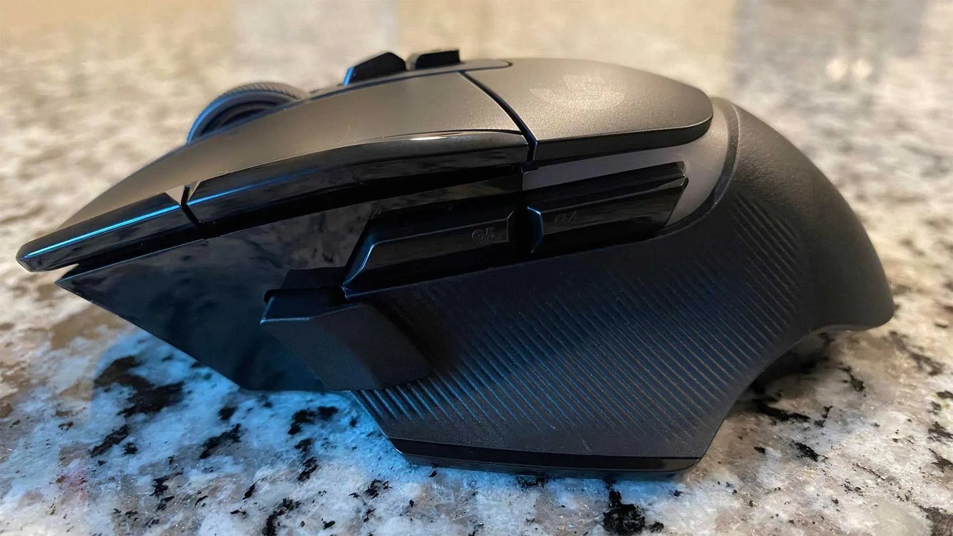 Hình ảnh cận cảnh chuột gaming không dây Logitech G502 X Plus màu đen từ góc nhìn bên cạnh, làm nổi bật các nút bấm có thể tùy chỉnh và thiết kế công thái học đặc trưng.