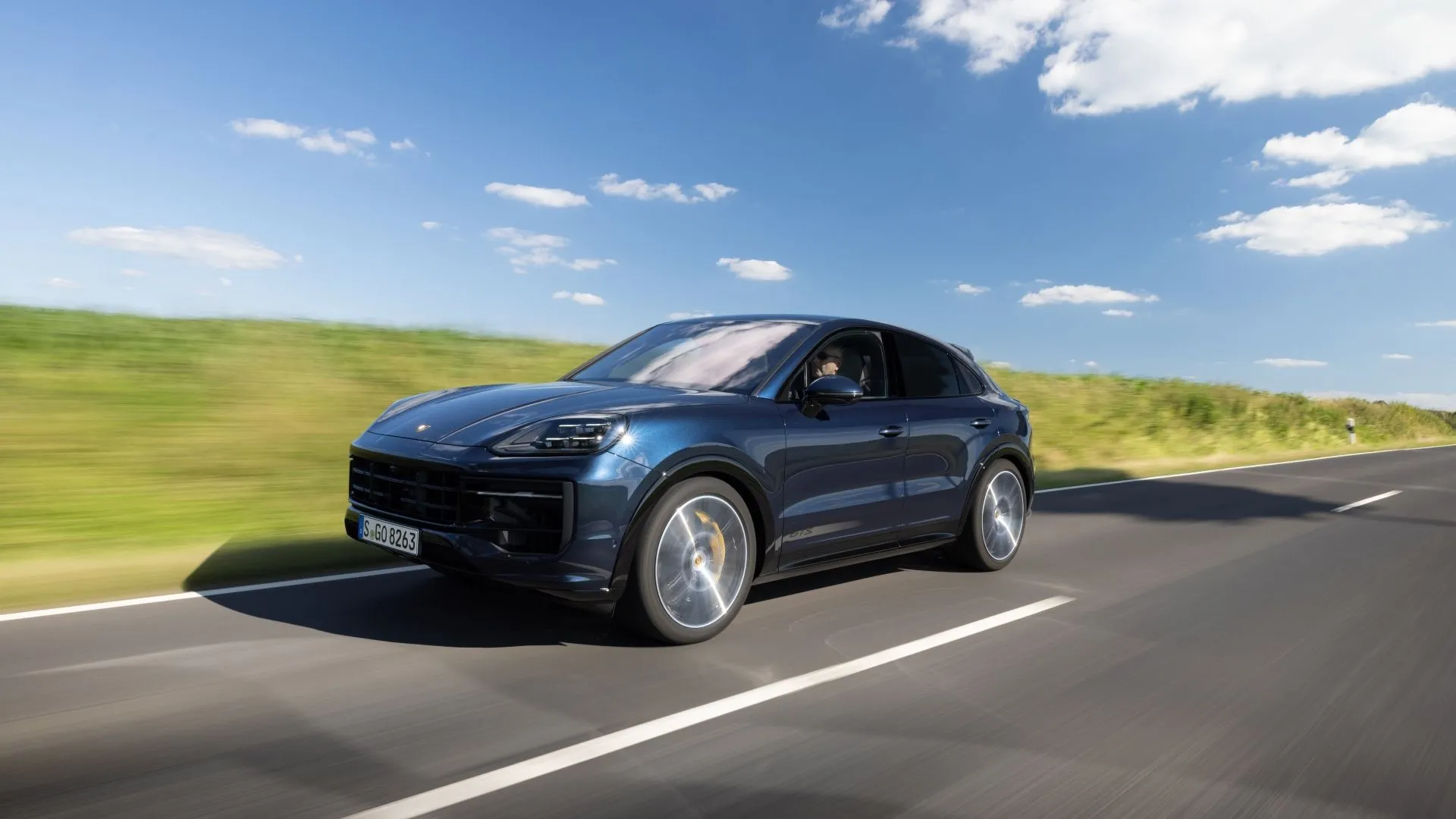 Hình ảnh góc 3/4 phía trước của Porsche Cayenne GTS 2025 màu xám bạc đang di chuyển