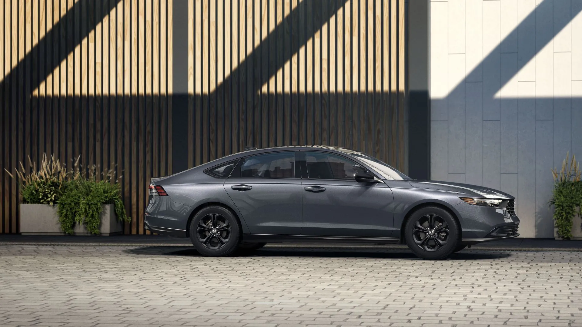 Honda Accord SE 2025 màu xám bạc đỗ bên ngoài một tòa nhà kiến trúc hiện đại