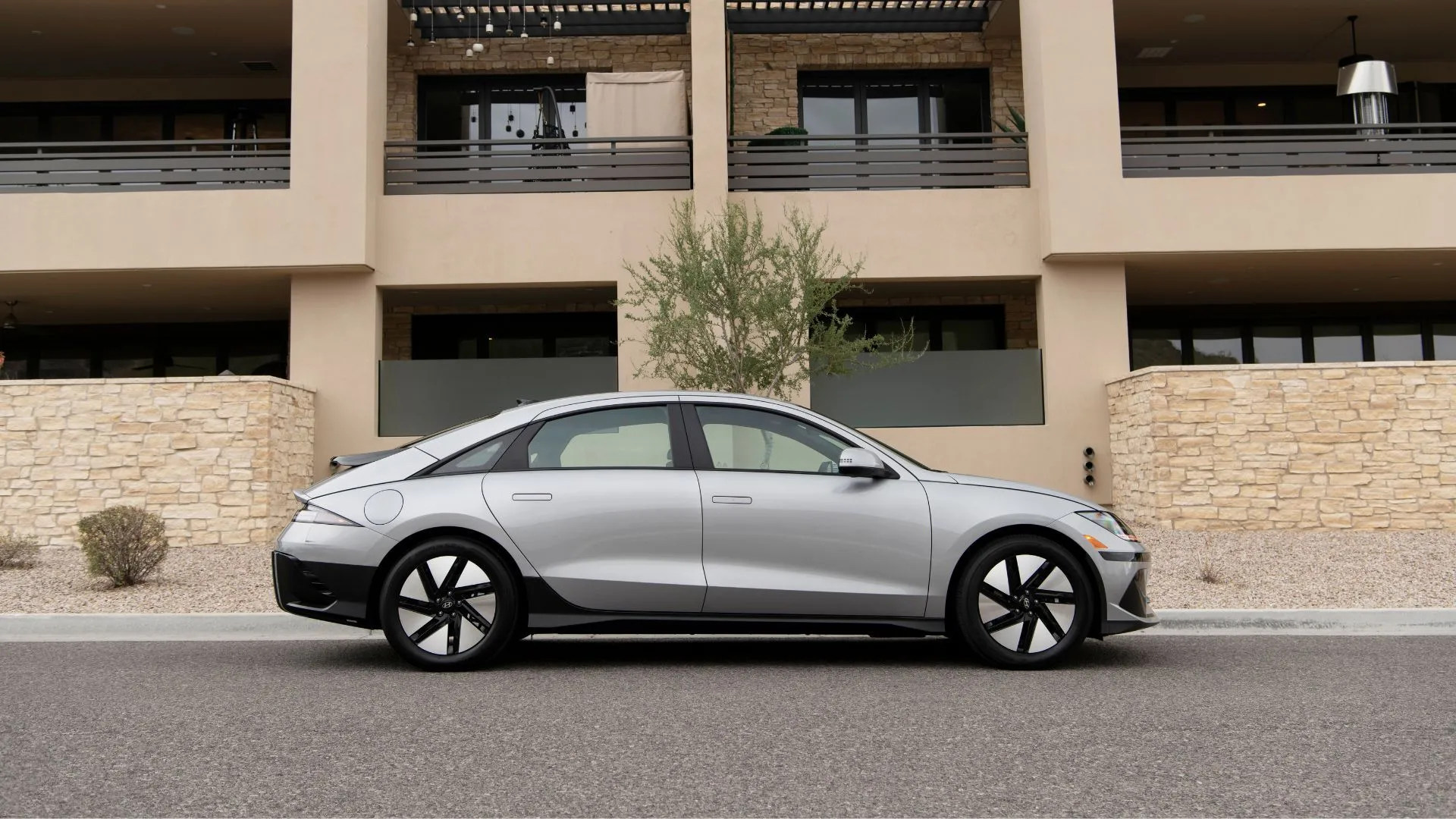 Hông xe Hyundai Ioniq 6 SE 2025 màu bạc đỗ trước tòa nhà dân cư