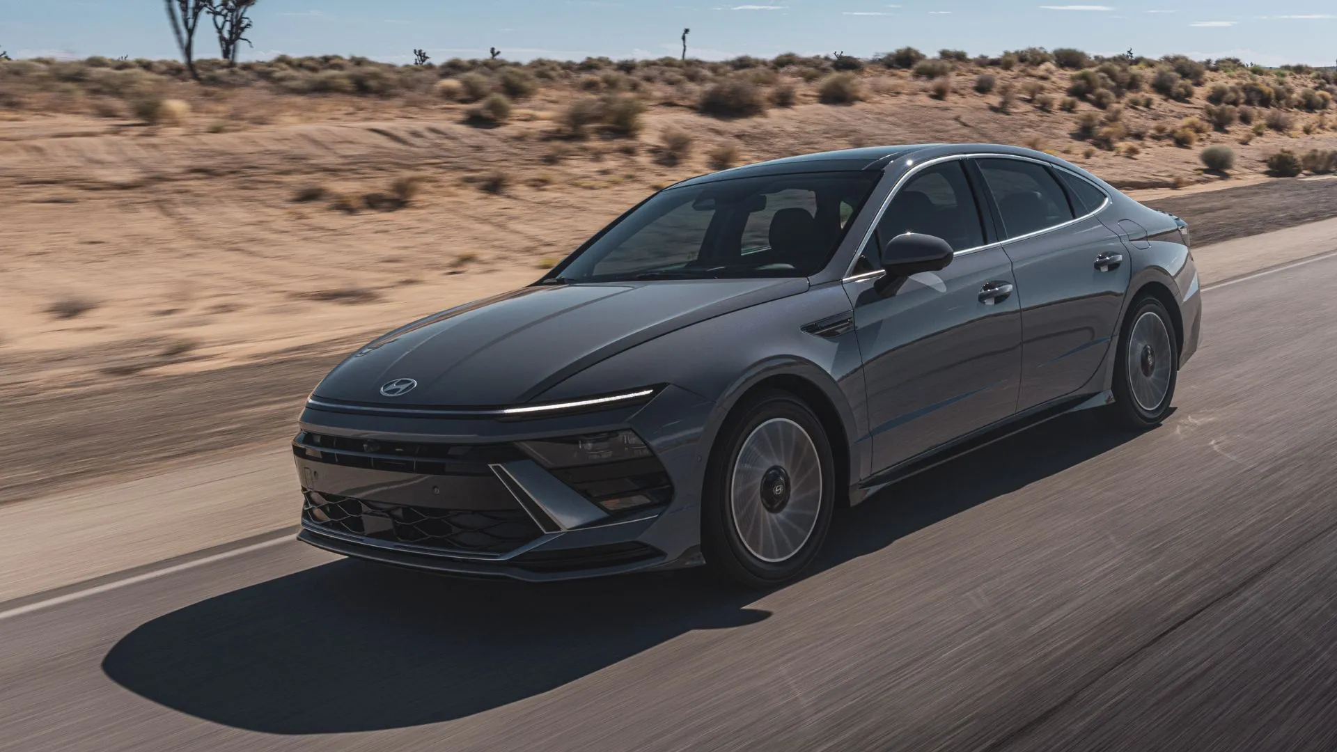 Hyundai Sonata Hybrid Limited 2025 màu xám di chuyển trên con đường nông thôn, kết hợp tiện nghi và đẳng cấp trong phân khúc sedan cỡ trung