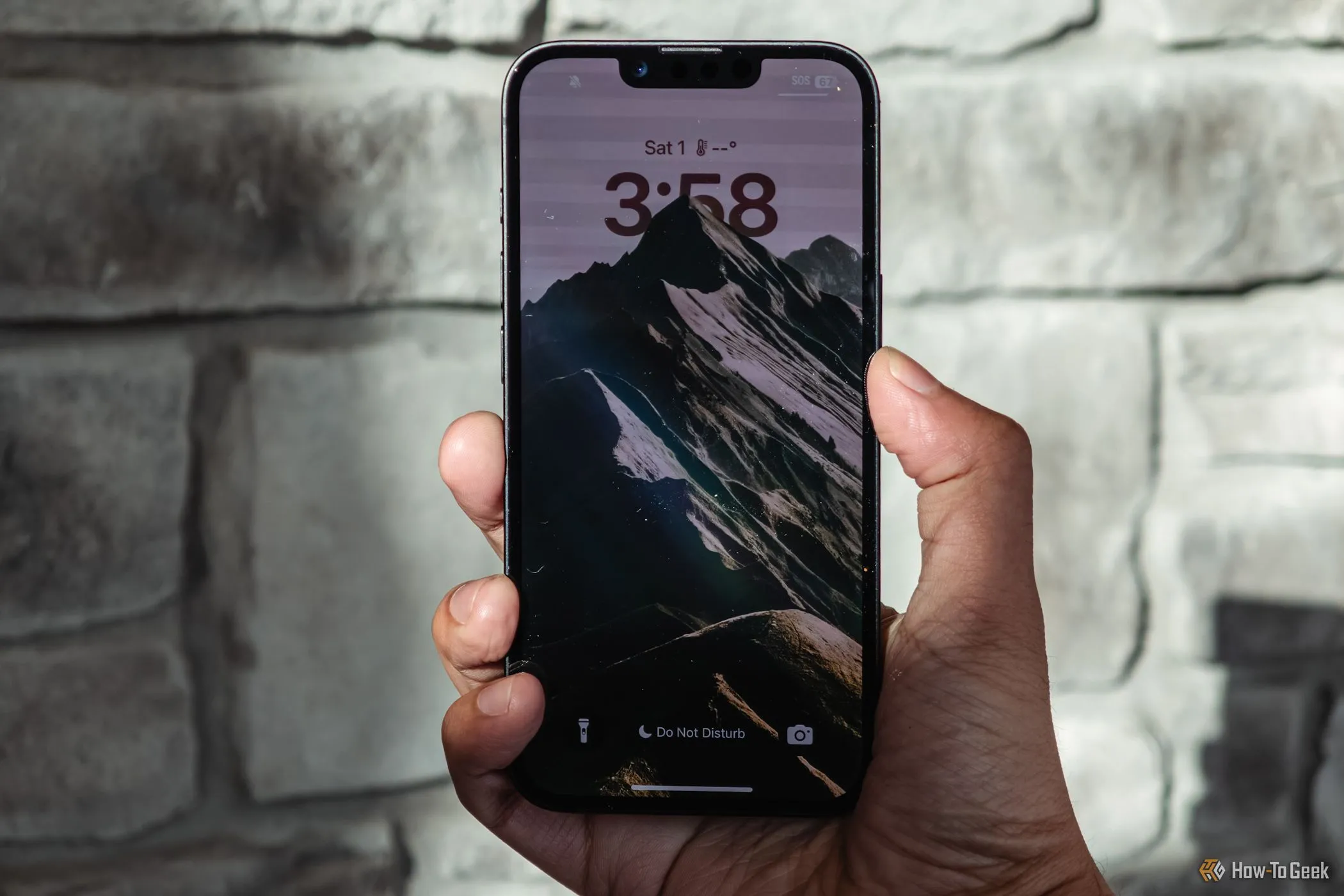 iPhone 16e màu trắng đang được cầm trên tay hiển thị màn hình khóa
