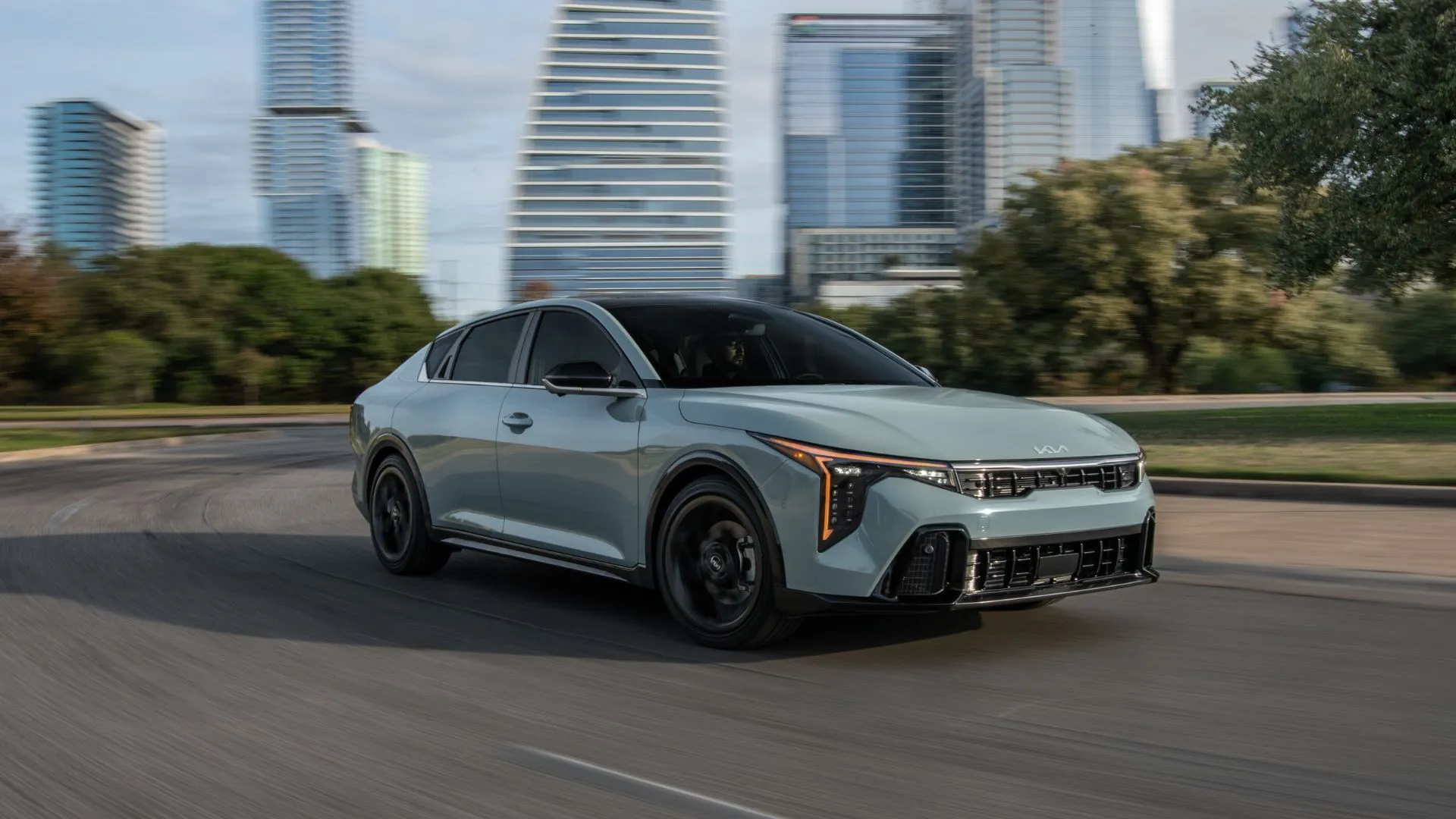 Kia K4 2025 màu xám lái qua thành phố