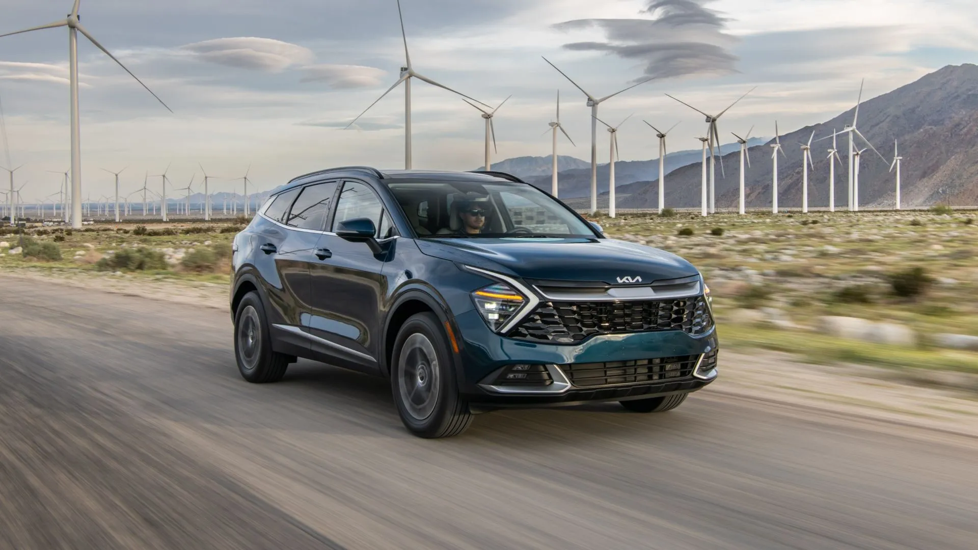 Kia Sportage Hybrid 2026 màu đen với thiết kế đầu xe ấn tượng đang lướt trên đường.
