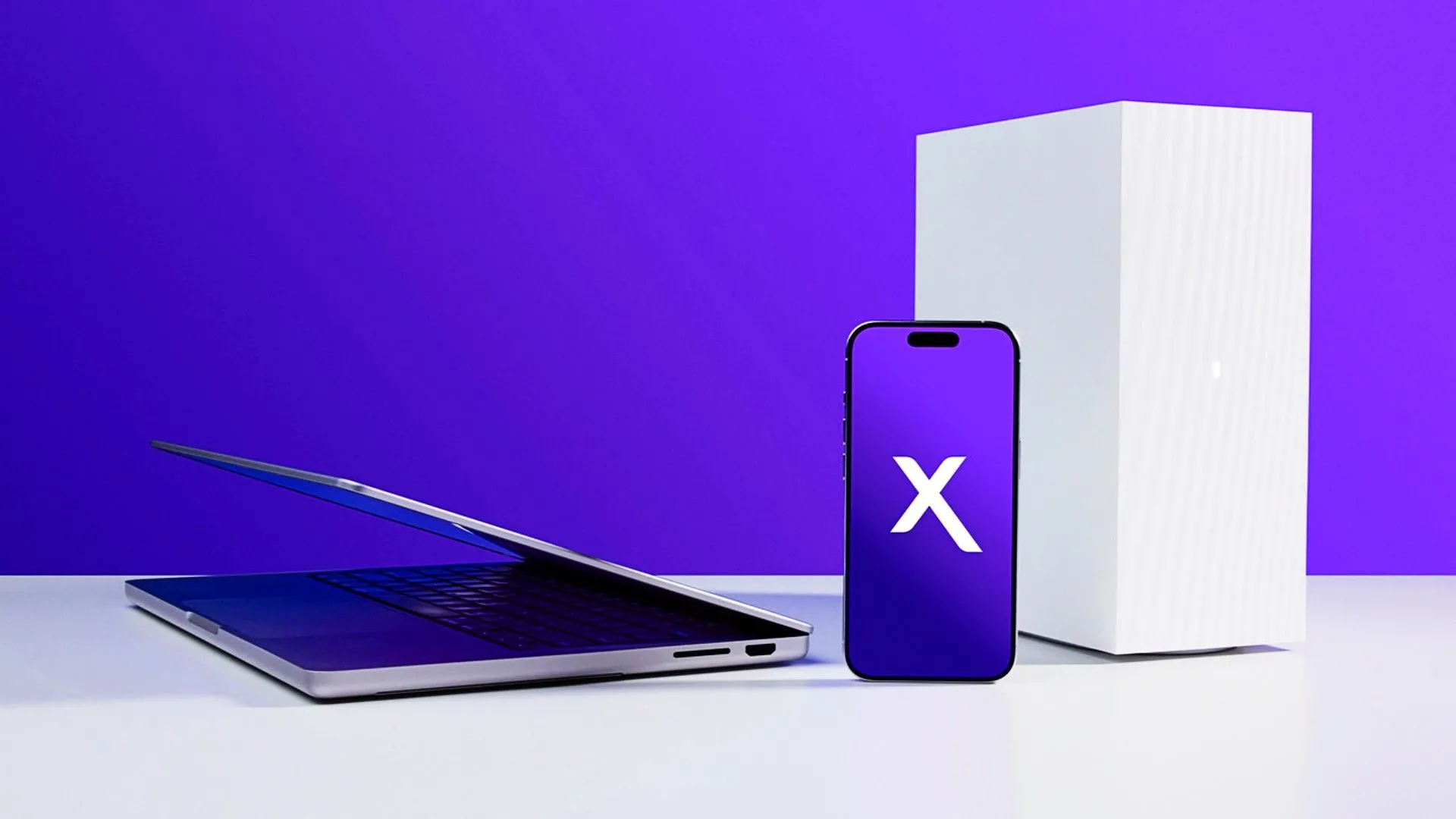 Laptop, điện thoại và case PC với logo Xfinity trên bề mặt trắng