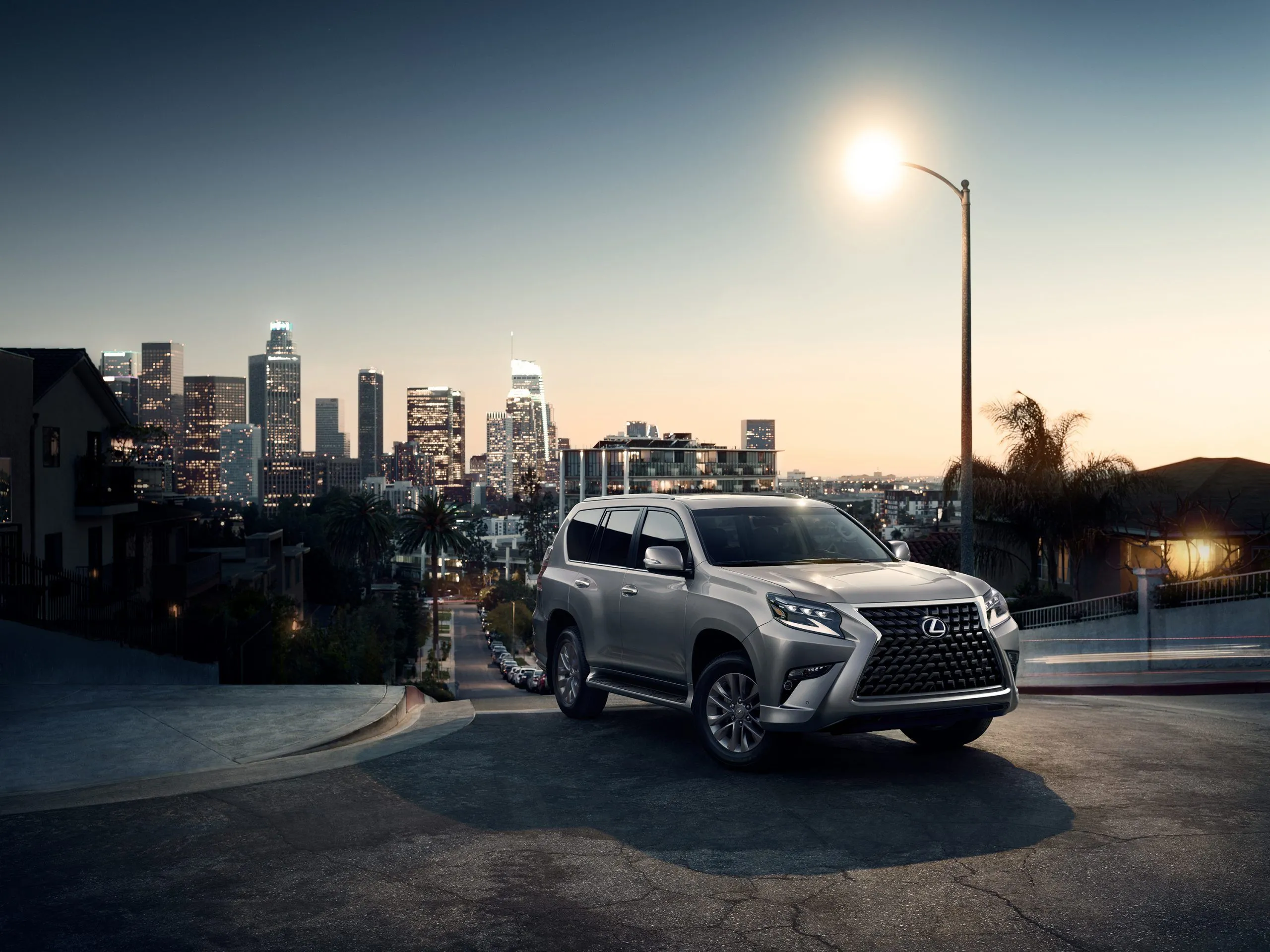 Lexus GX 460 2022 màu bạc đỗ trên đường phố dưới ánh đèn đường, một SUV địa hình sang trọng và bền bỉ.
