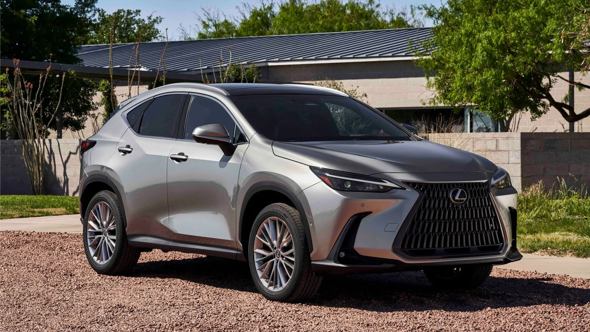 Lexus NX 350h Premium AWD 2025 màu xám bạc tĩnh lặng trước tòa nhà hiện đại, thể hiện sự sang trọng và tiết kiệm nhiên liệu