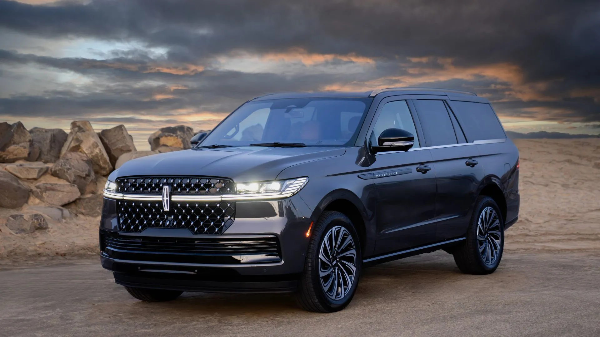 Lincoln Navigator Black Label 2025 sang trọng đứng vững trên nền đá, bầu trời nhiều mây, thể hiện đẳng cấp của dòng SUV cao cấp Lincoln.