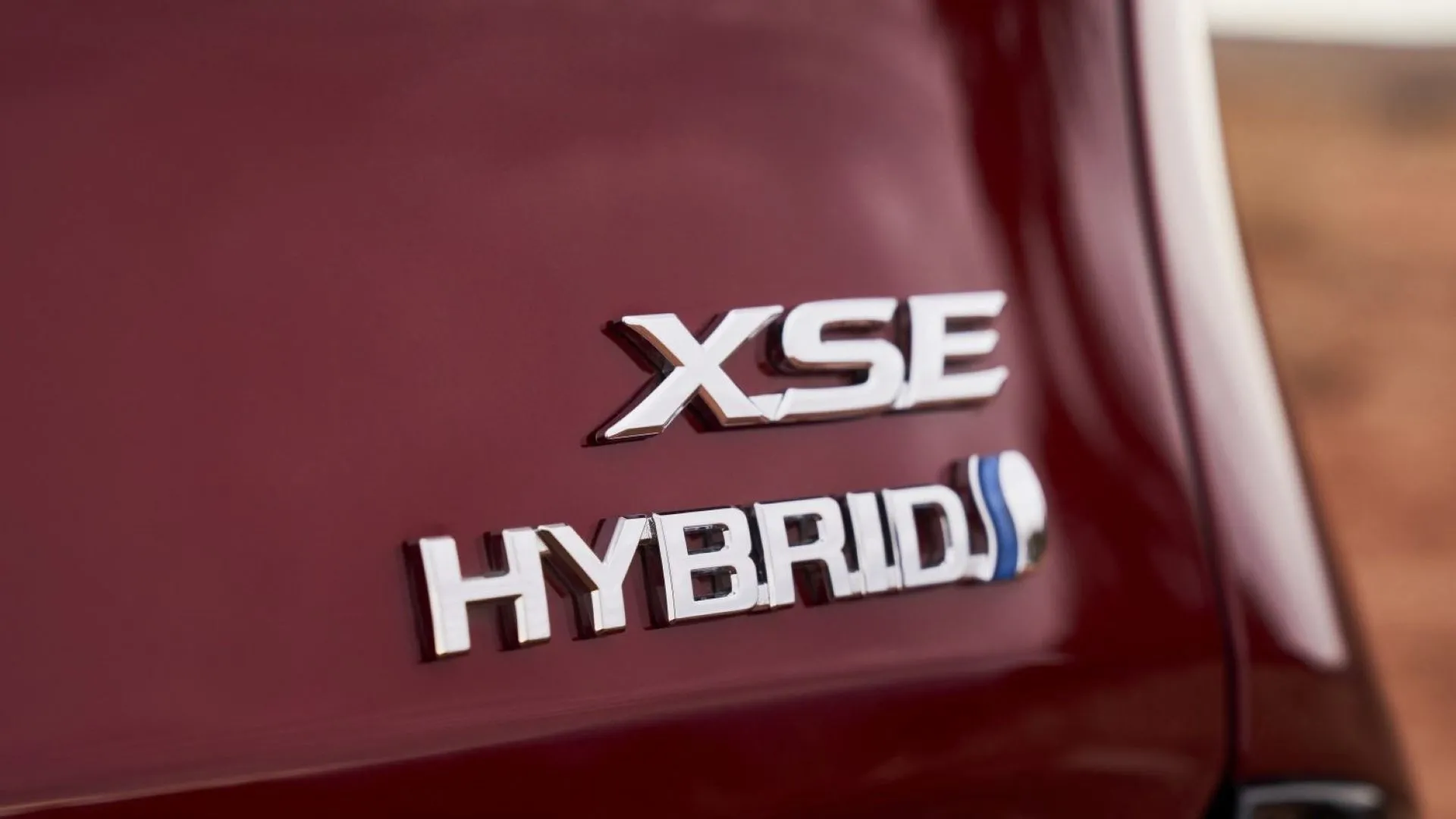 Logo Hybrid trên thân xe Toyota Sienna XSE 2025 màu đỏ, biểu tượng cho hệ truyền động tiết kiệm nhiên liệu và thân thiện môi trường.