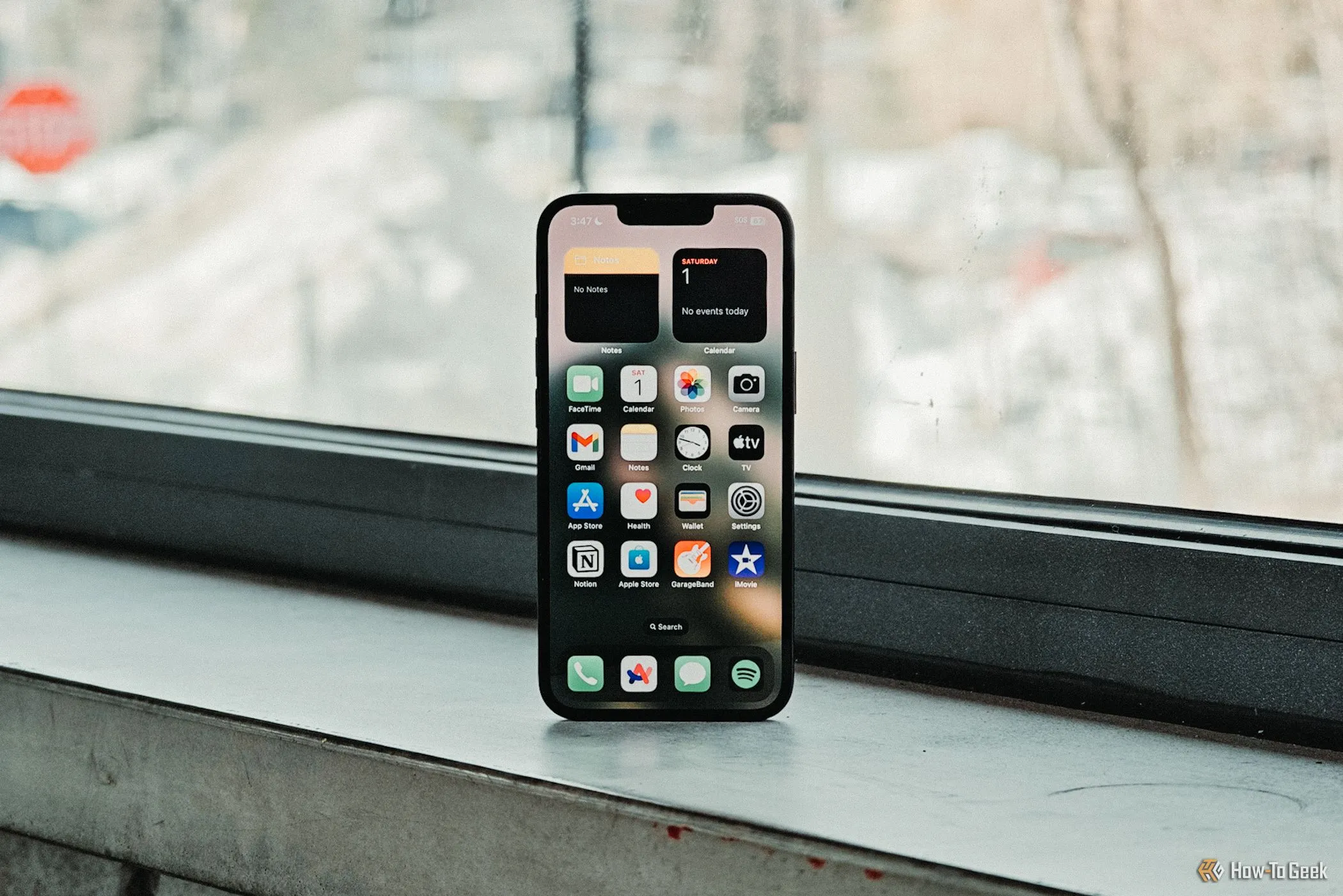 Màn hình chính iPhone 16e màu trắng trước cửa sổ