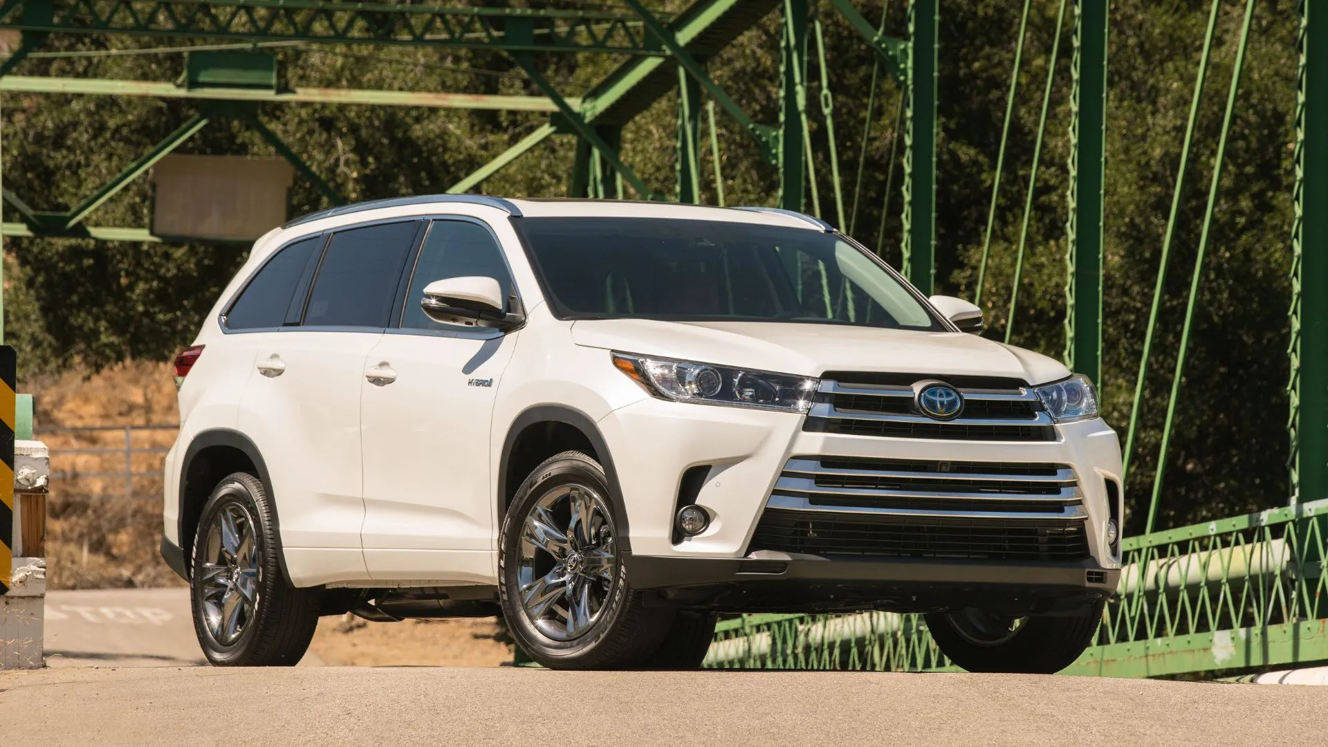 Mẫu SUV gia đình Toyota Highlander Hybrid 2017 màu trắng đậu trên cầu, biểu tượng của sự rộng rãi và bền bỉ.