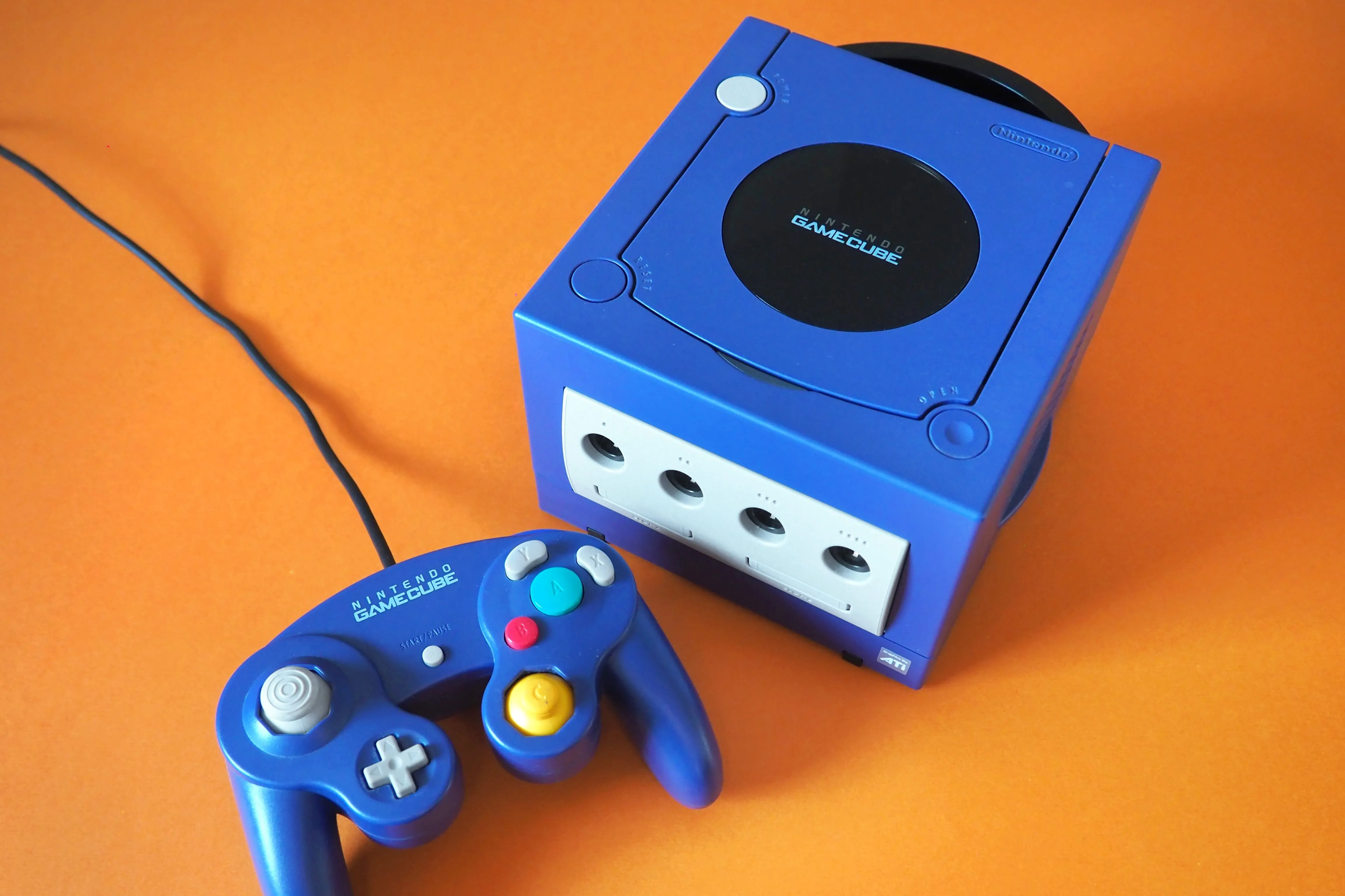 Máy chơi game Nintendo GameCube màu xanh dương đặc trưng trên nền cam
