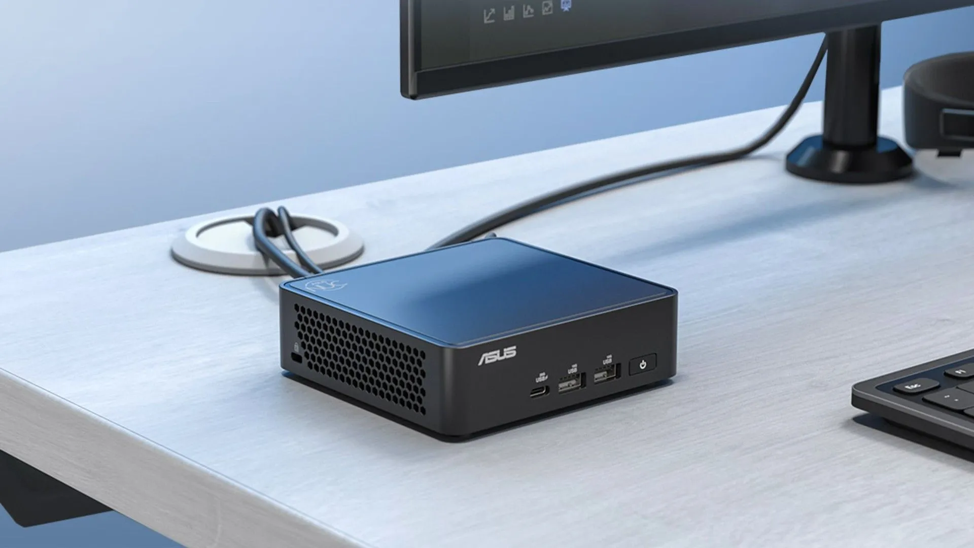 Máy tính mini ASUS NUC 15 Pro được kết nối với màn hình, cho thấy sự nhỏ gọn của nó