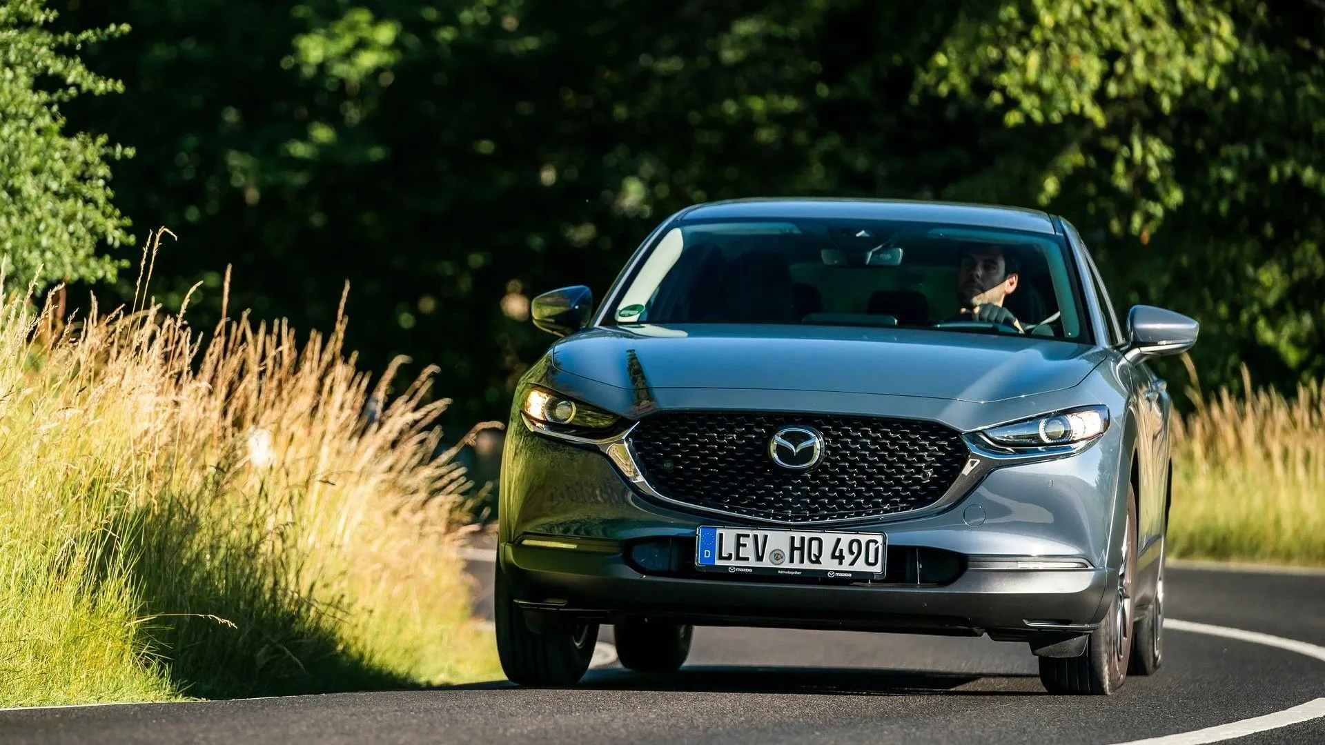 Mazda CX-30 2020 màu đỏ đang di chuyển trên đường, nổi bật với thiết kế thể thao và năng động