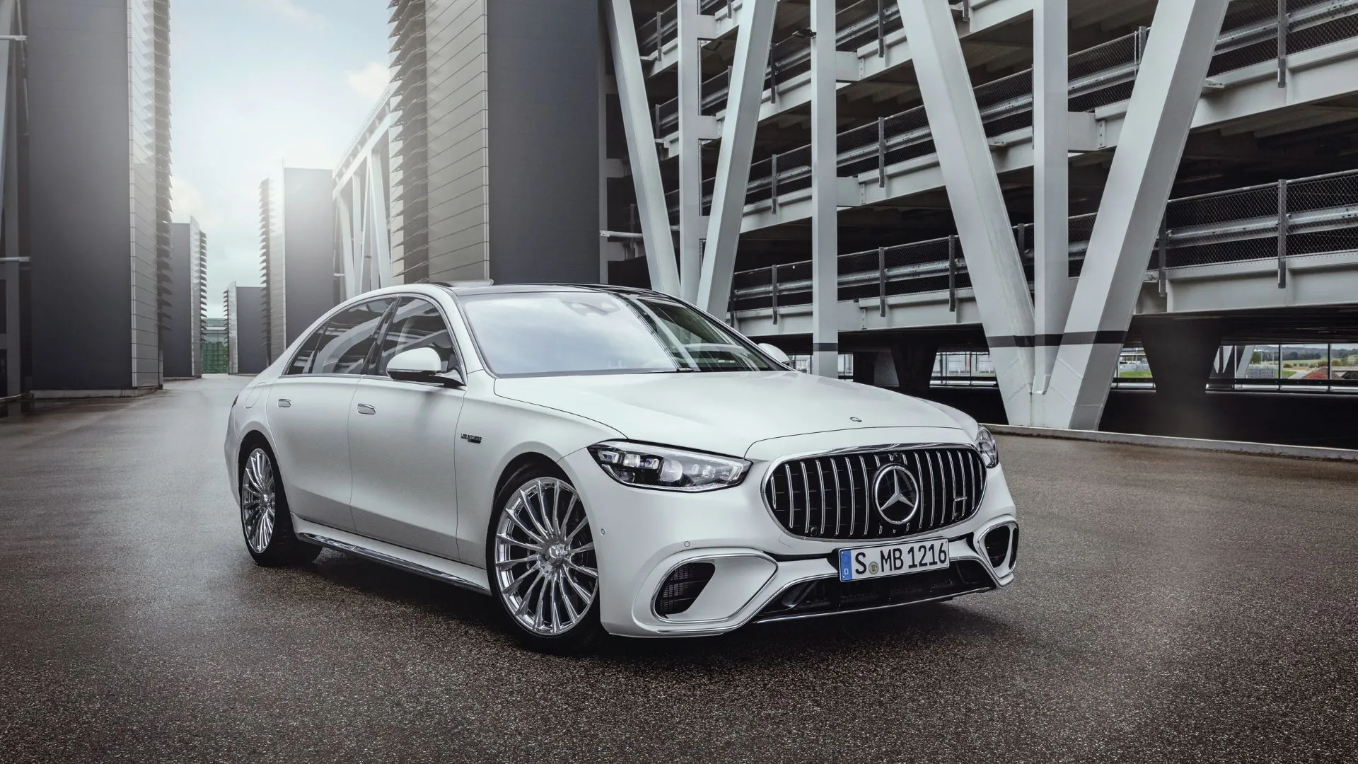 Mercedes-AMG S 63 E Performance 2025 màu trắng đỗ trên đường nhựa giữa các tòa nhà, biểu tượng của sedan hạng sang