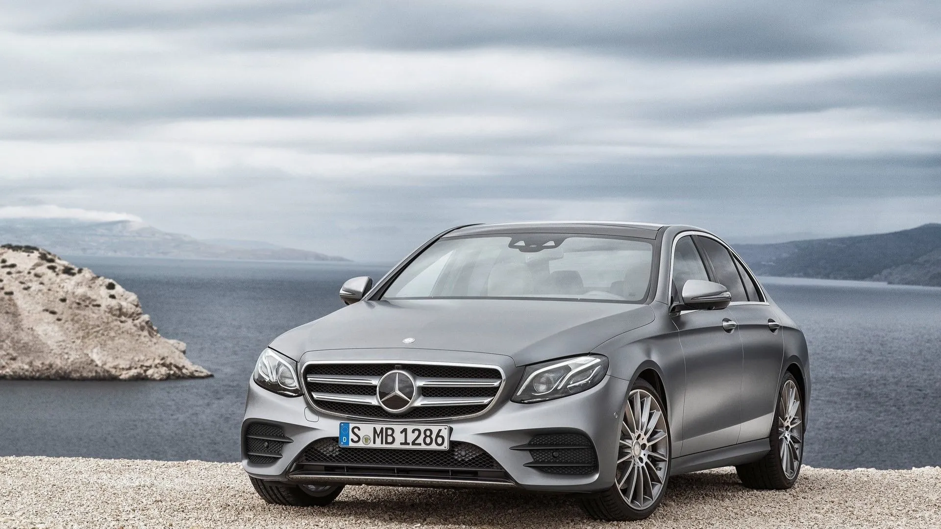 Mercedes-Benz E-Class 2017 màu bạc lịch lãm di chuyển trên đường, biểu tượng của sự sang trọng và công nghệ tiên tiến trong phân khúc sedan hạng sang.