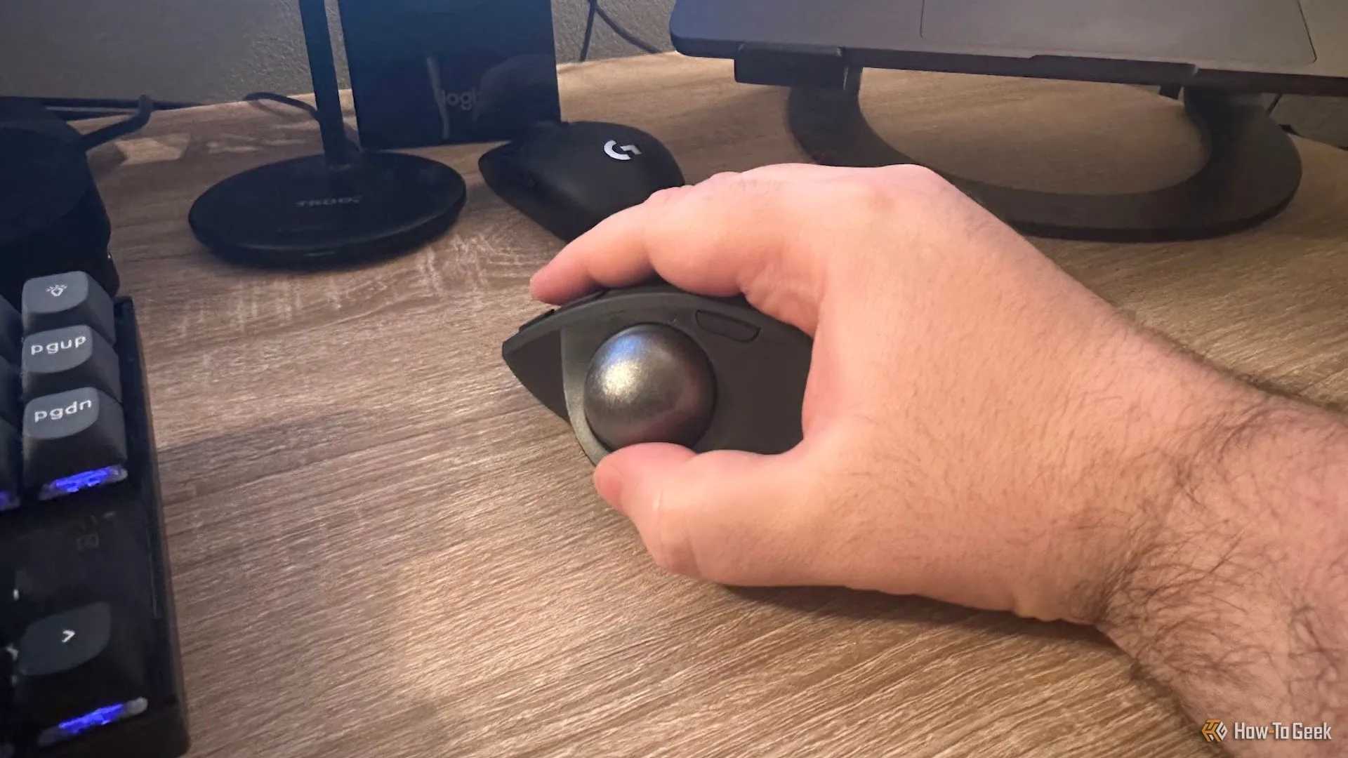 Một bàn tay đang cầm chuột Logitech MX Ergo S với thiết kế công thái học