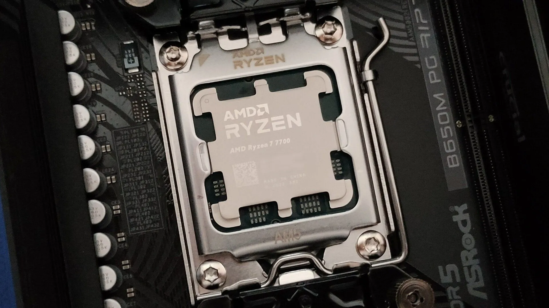Một hình ảnh cận cảnh CPU AMD Ryzen 7 7700 trên socket AM5 và bo mạch chủ ASRock B650M PG Riptide.