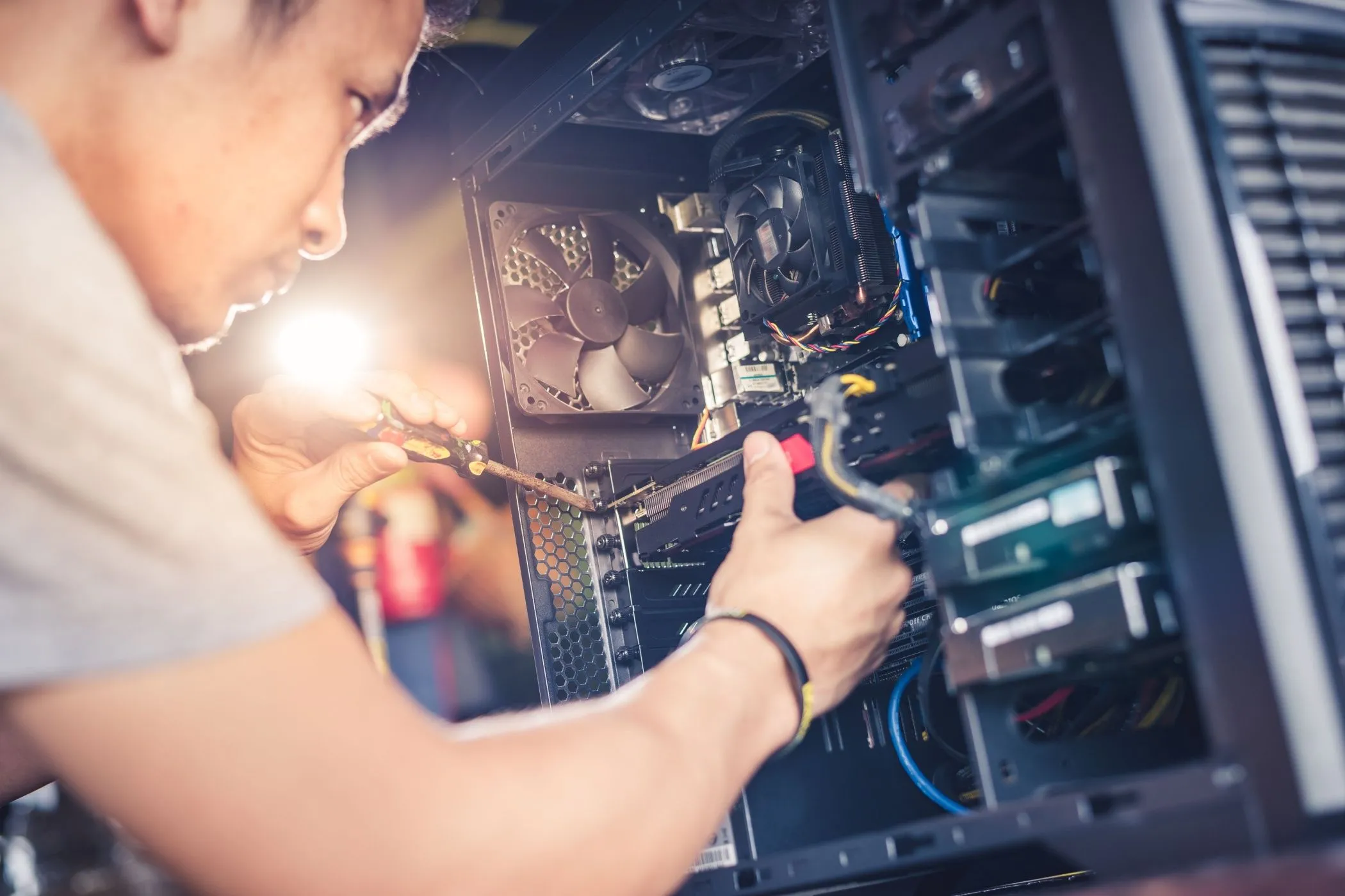 Một người đang cài đặt card đồ họa vào máy tính, thể hiện công việc hỗ trợ kỹ thuật và xây dựng PC