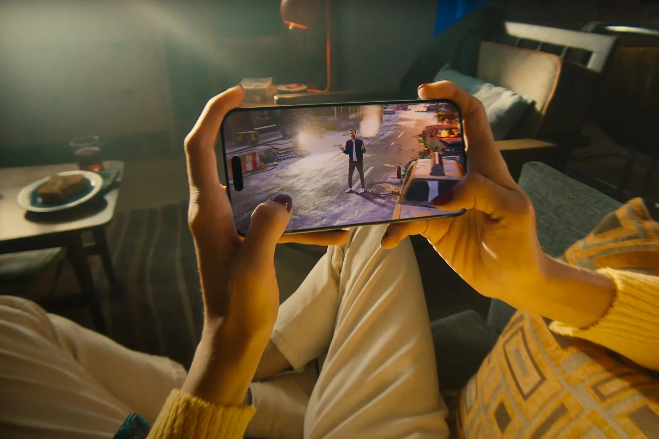 Một người đang cầm iPhone 15 Pro chơi game, gợi ý hoạt động giải trí thay thế cho doomscrolling