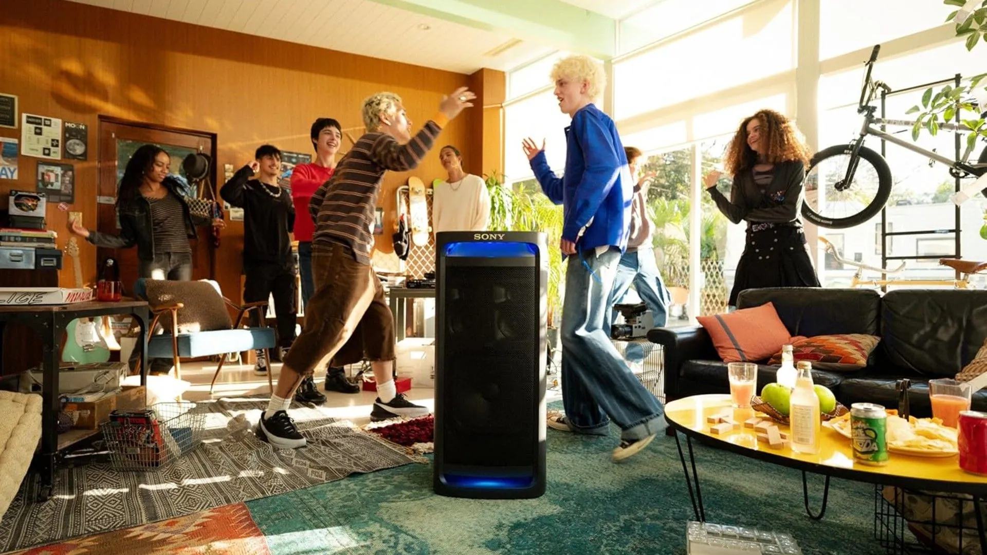 Một nhóm bạn trẻ đang tiệc tùng vui vẻ bên cạnh loa Sony ULT Tower 9, thể hiện không khí sôi động của bữa tiệc
