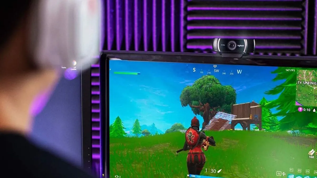 Một streamer chơi Fortnite, sử dụng webcam Logitech C922x Pro Stream được kết nối qua cổng USB của Xbox để phát trực tiếp hình ảnh người chơi.