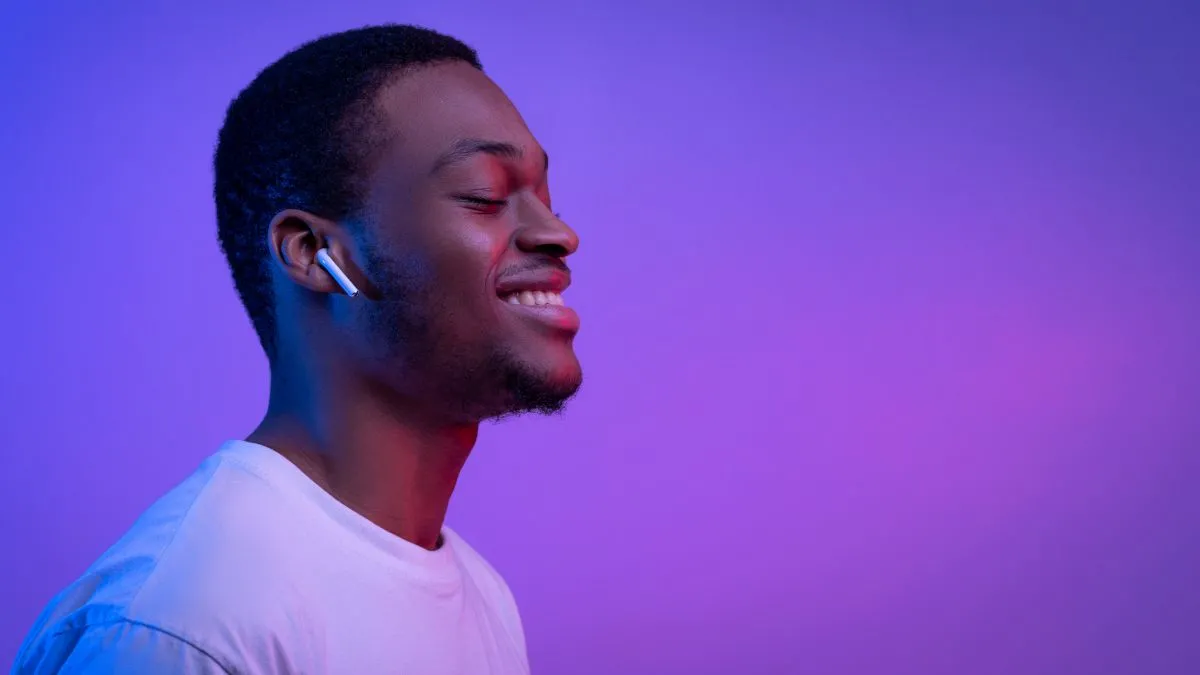 Người đàn ông thư giãn đeo Apple Airpods, một phương pháp thiền không màn hình có thể giúp giảm sự phụ thuộc vào ứng dụng điện thoại.