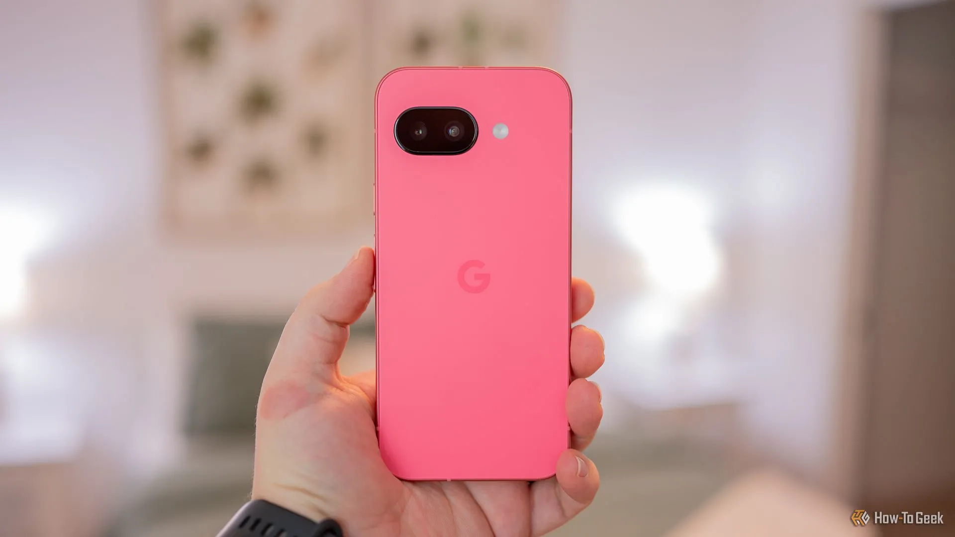 Người dùng cầm điện thoại Google Pixel 9a màu Iris, khoe thiết kế mặt lưng và cụm camera mới.
