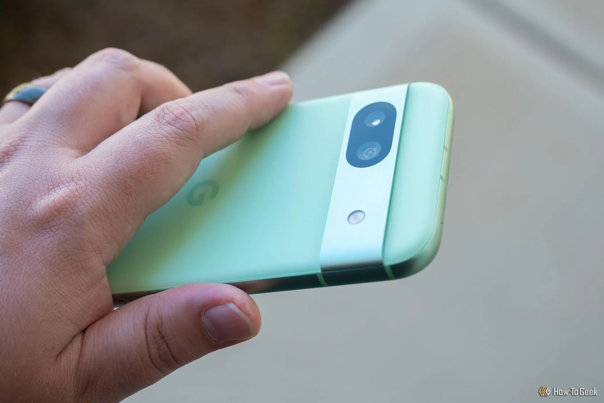 Người dùng cầm Google Pixel 8a với thiết kế camera sau đặc trưng, một đối thủ của Galaxy A16 về chính sách hỗ trợ phần mềm