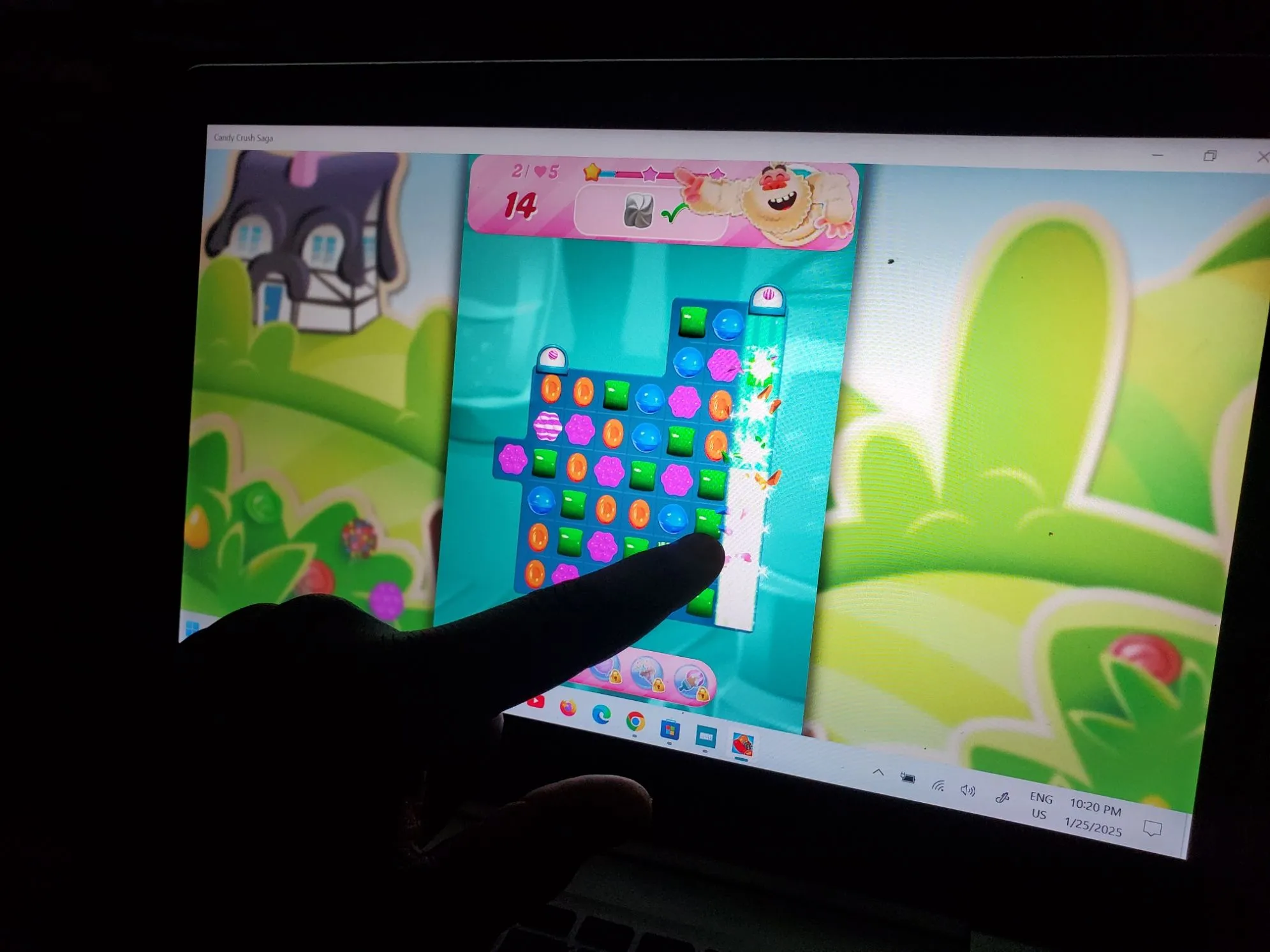 Người dùng chơi game Candy Crush trên laptop màn hình cảm ứng
