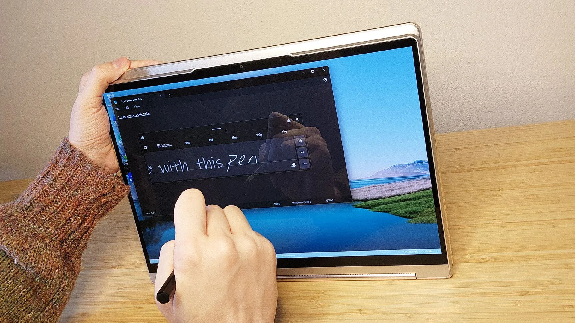 Người dùng đang sử dụng bút stylus để viết trên màn hình laptop Lenovo Yoga