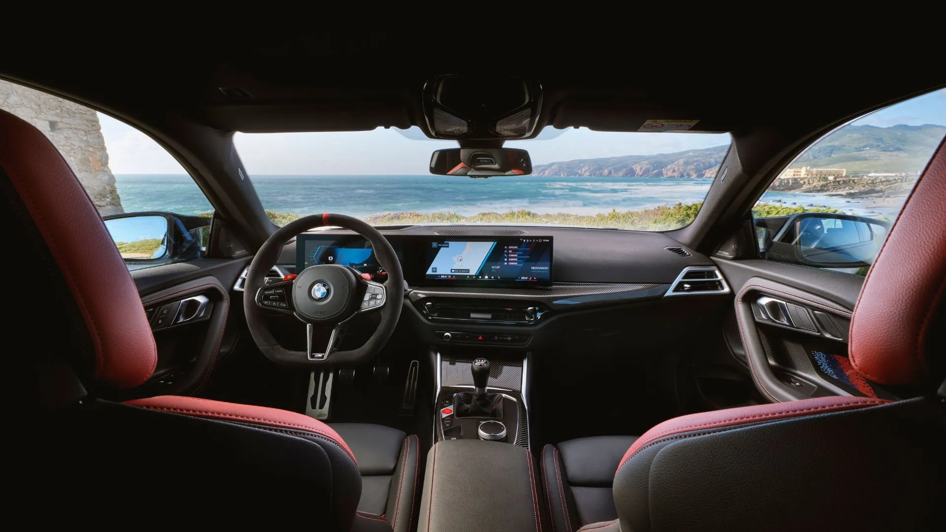 Nội thất khoang lái của BMW M2 2025, với ghế trước thể thao và màn hình giải trí trung tâm