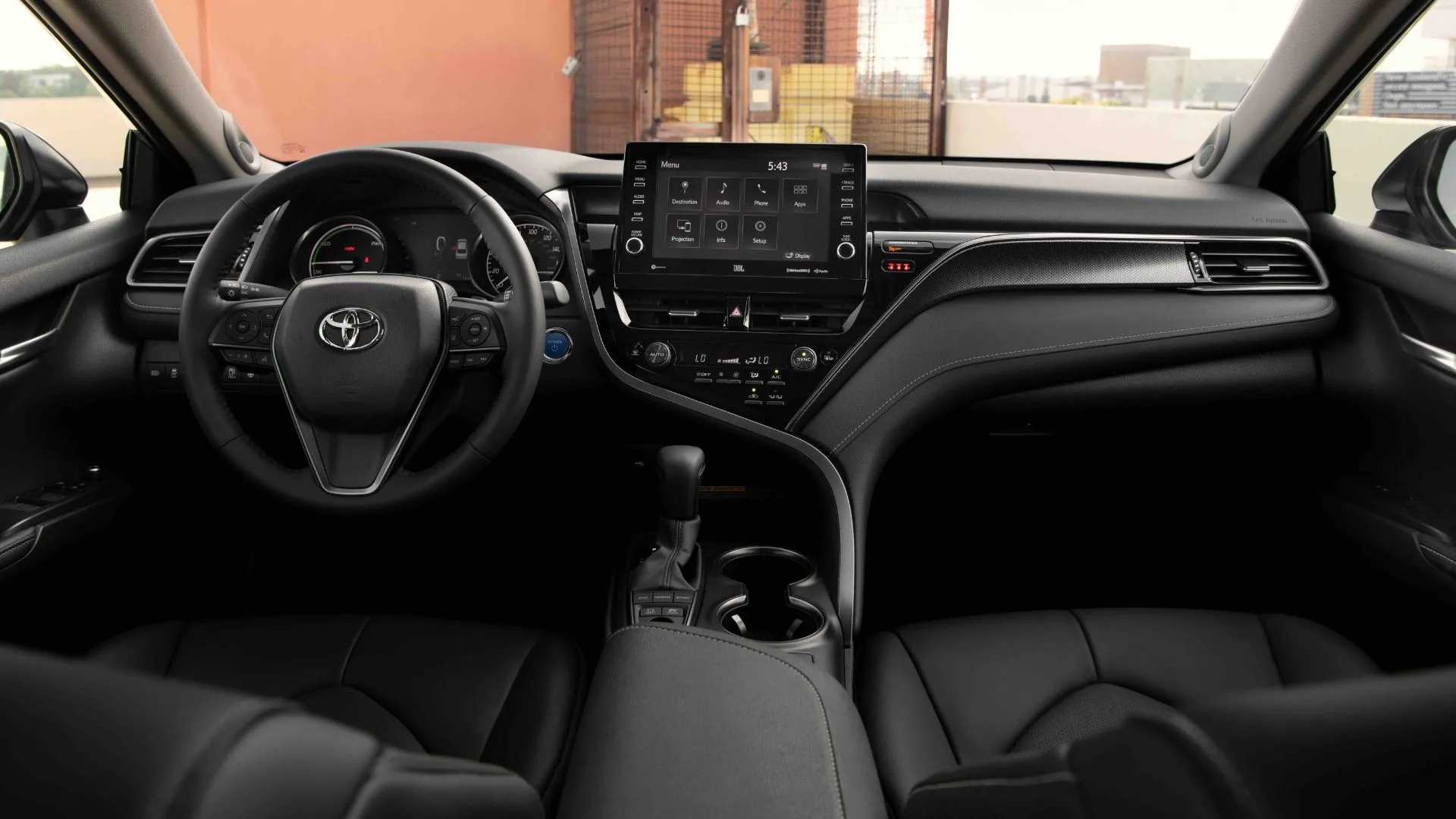 Nội thất màu đen của Toyota Camry 2022 hiển thị bảng điều khiển với vô lăng và màn hình thông tin giải trí