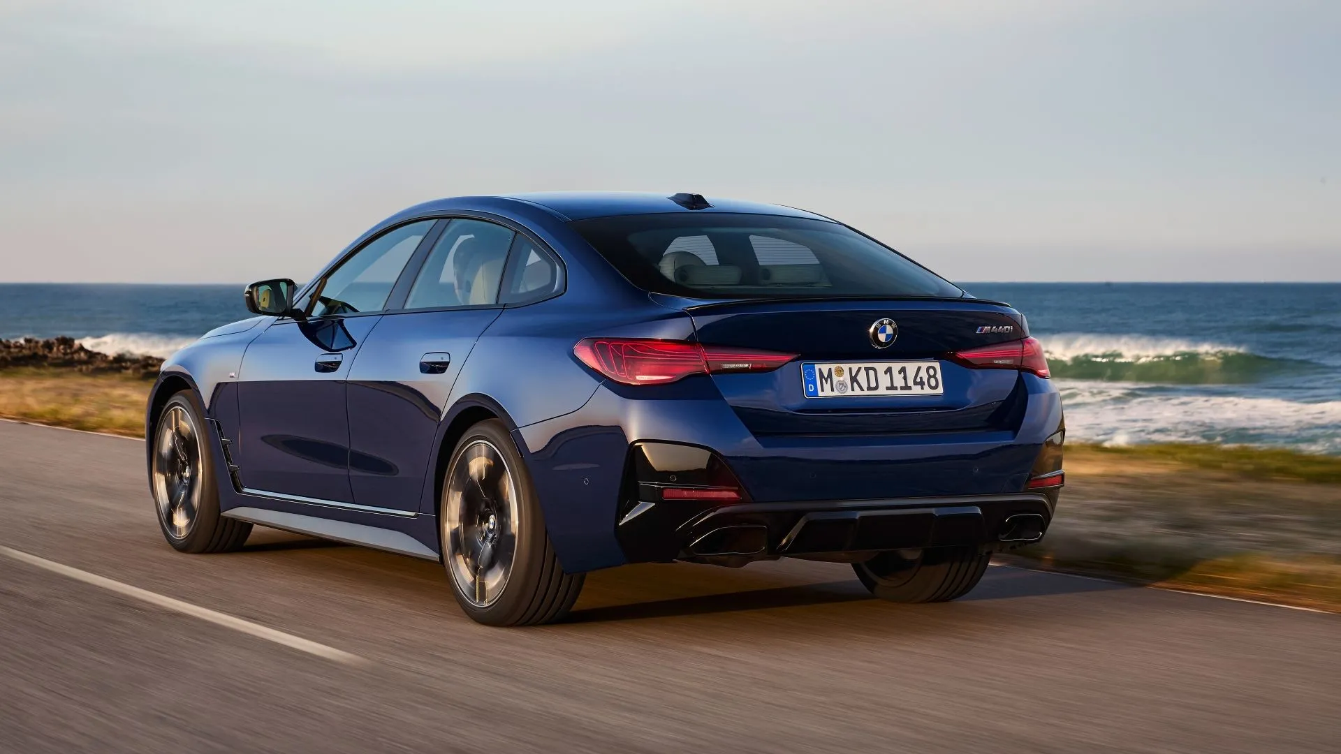 Phần đuôi xe BMW i4 2025 màu xanh ngọc đang chạy, góc nhìn phía sau