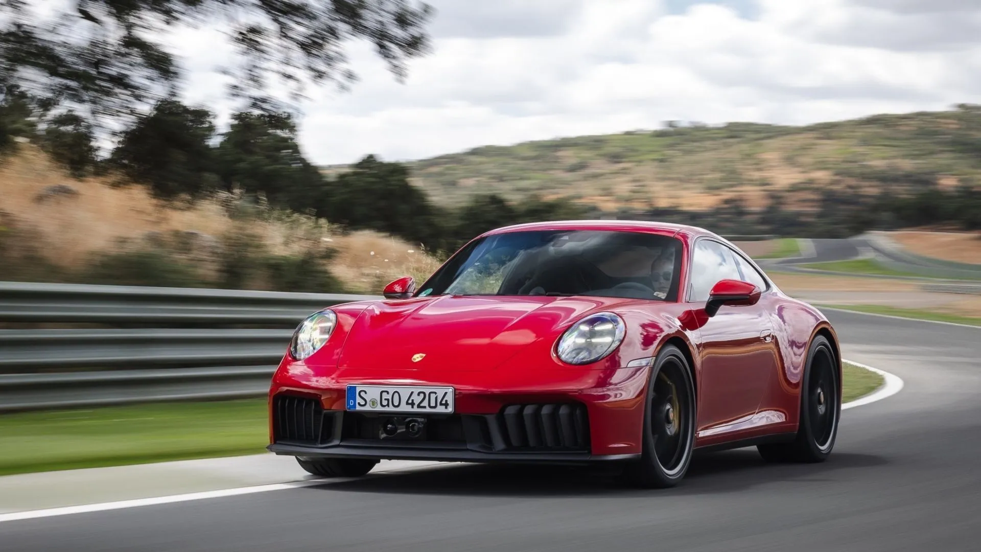 Porsche 911 Carrera 4 GTS 2025 màu đỏ trên đường đua, biểu tượng xe thể thao có tỷ lệ khấu hao nhất định