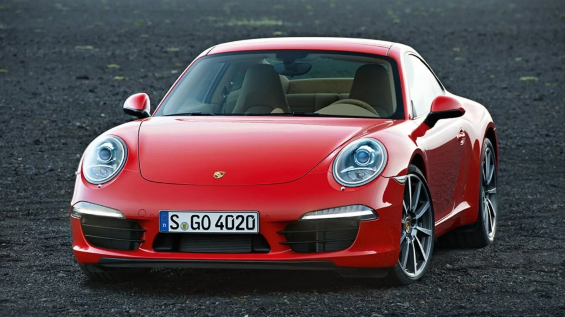 Porsche 911 Carrera 991 đời 2012 màu đỏ đỗ trên nền sỏi, biểu tượng xe thể thao với trải nghiệm lái thuần khiết