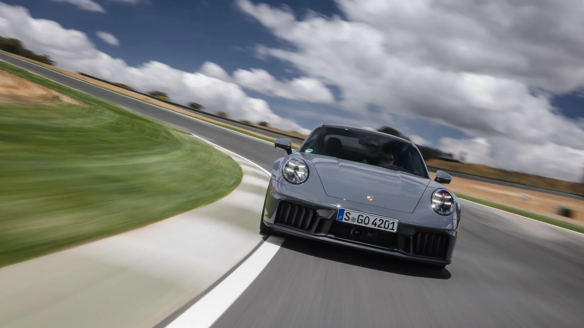 Porsche 911 Carrera GTS 2025 màu đỏ đang vận hành tốc độ cao, thể hiện hiệu suất mạnh mẽ