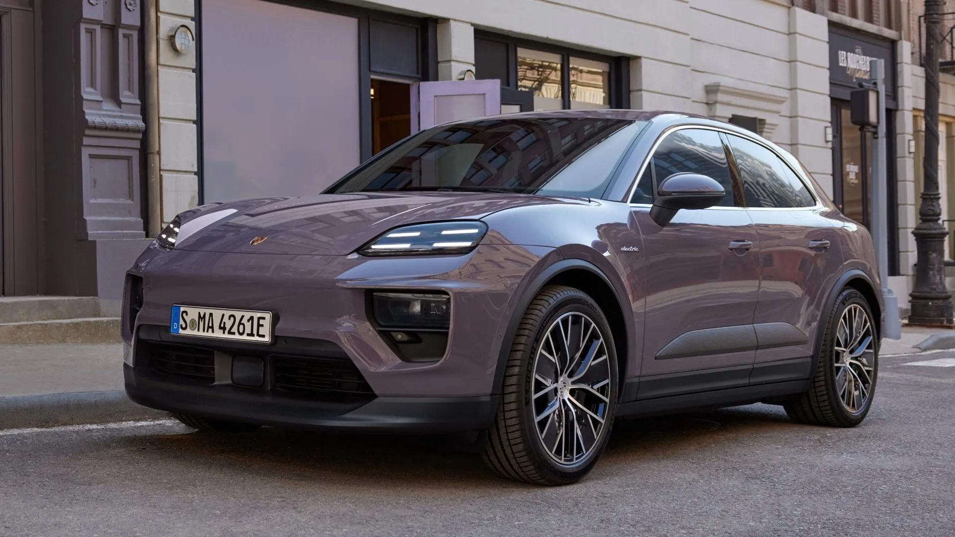Porsche Macan 2025 màu đen nhìn từ góc 3/4 phía trước, mẫu SUV thể thao hạng sang