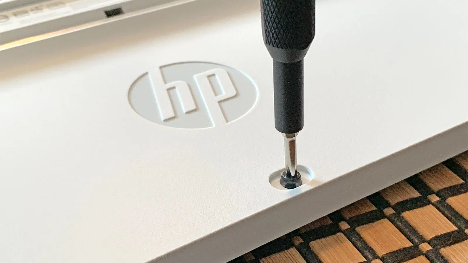 Sử dụng tua vít để tháo ốc bàn phím laptop trong quá trình vệ sinh PC