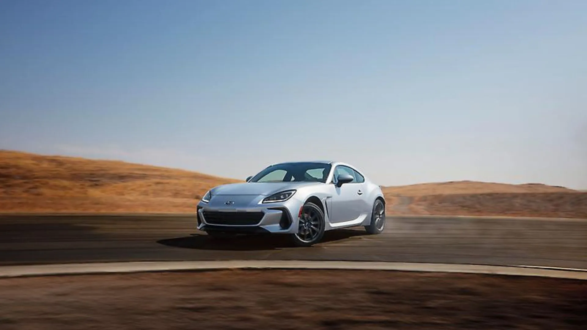 Subaru BRZ 2024 màu bạc đang drift quanh góc cua trên đường đua, thể hiện khả năng vận hành thể thao và niềm vui lái xe.