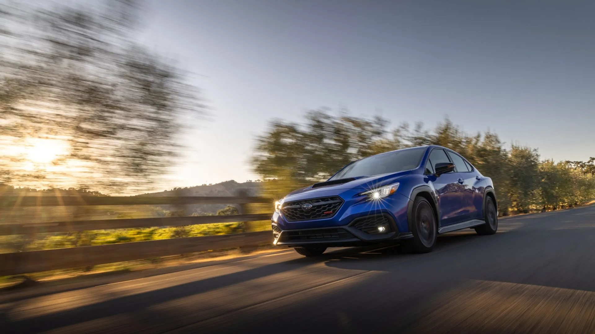 Subaru WRX tS 2025 màu xanh đậm đang lướt đi, một biểu tượng xe đua rally vẫn giữ tùy chọn hộp số sàn 6 cấp.