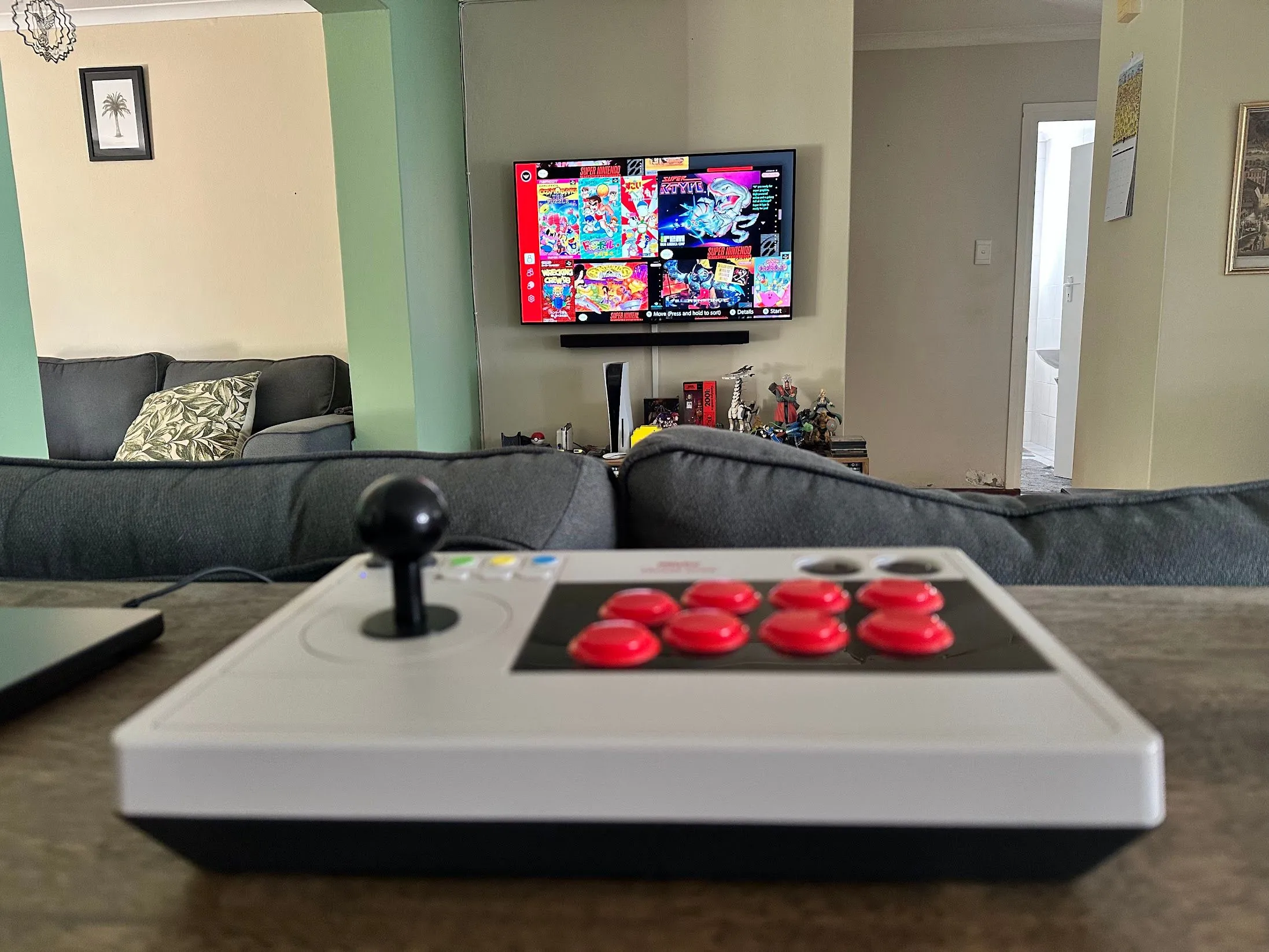 Tay cầm arcade 8BitDo cùng màn hình hiển thị các tựa game SNES cổ điển, gợi nhớ trải nghiệm game thùng