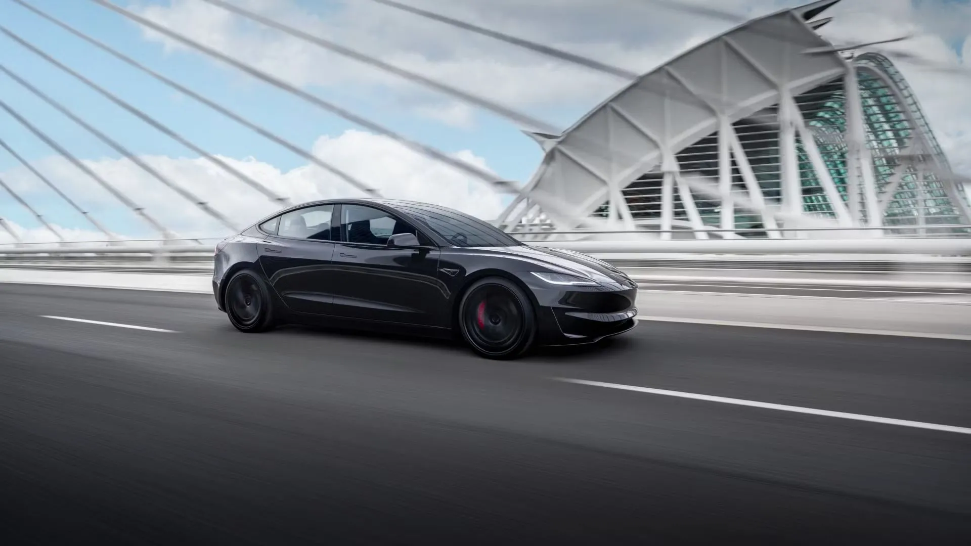 Tesla Model 3 Performance 2024 màu xám đậm đang chạy trên cầu, nhìn từ góc bên, nhấn mạnh sự thanh lịch và hiệu suất cao của xe điện