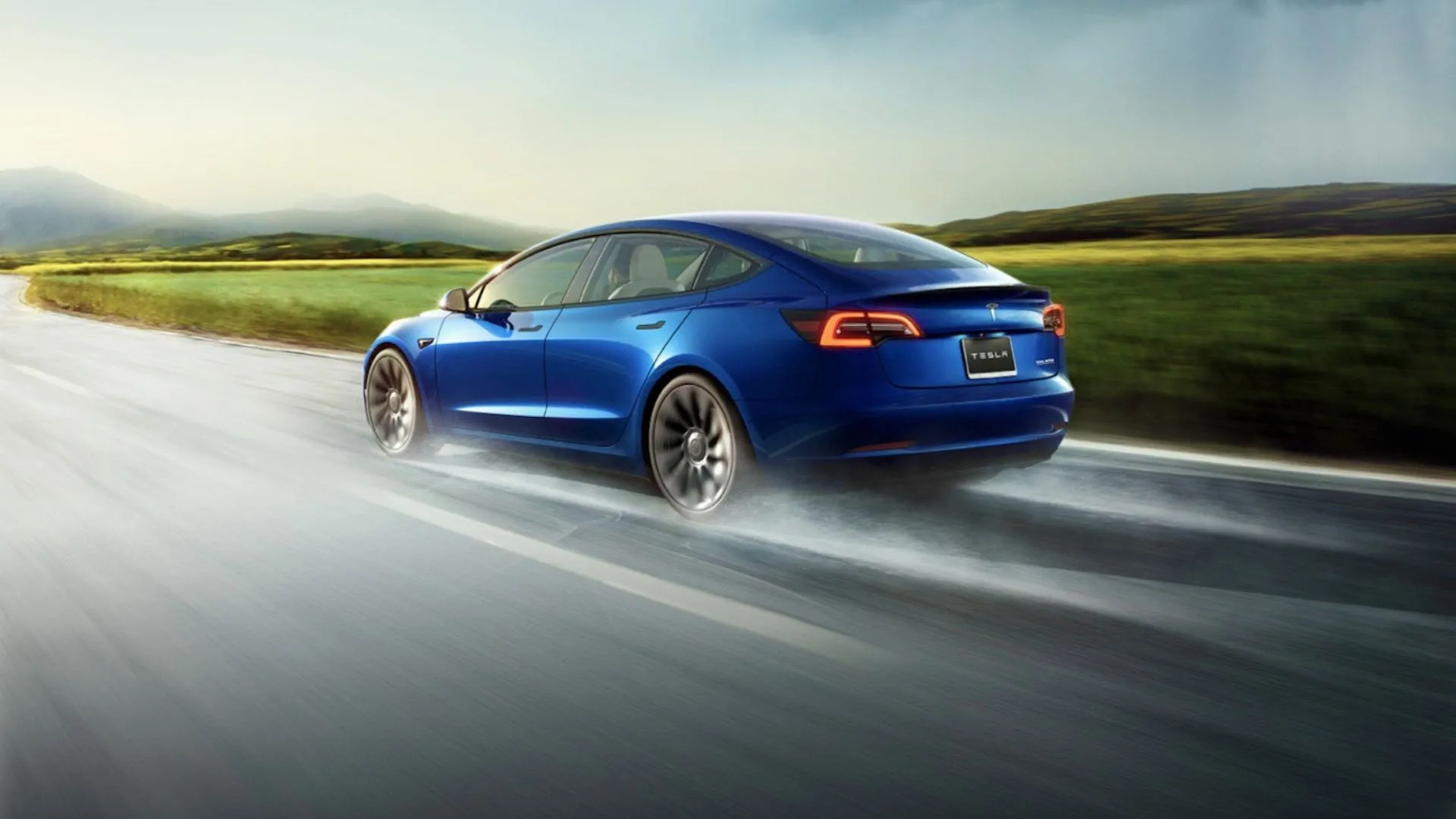 Tesla Model 3 Performance màu xanh đang lái trên đường ướt, nhấn mạnh hiệu suất vận hành mạnh mẽ.