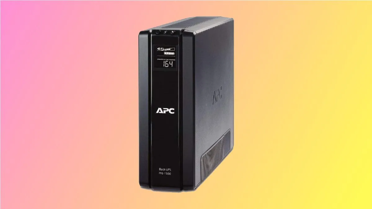 Thiết bị chống sét APC UPS màu đen với nhiều ổ cắm và màn hình LCD nhỏ, đặt trên nền hồng.