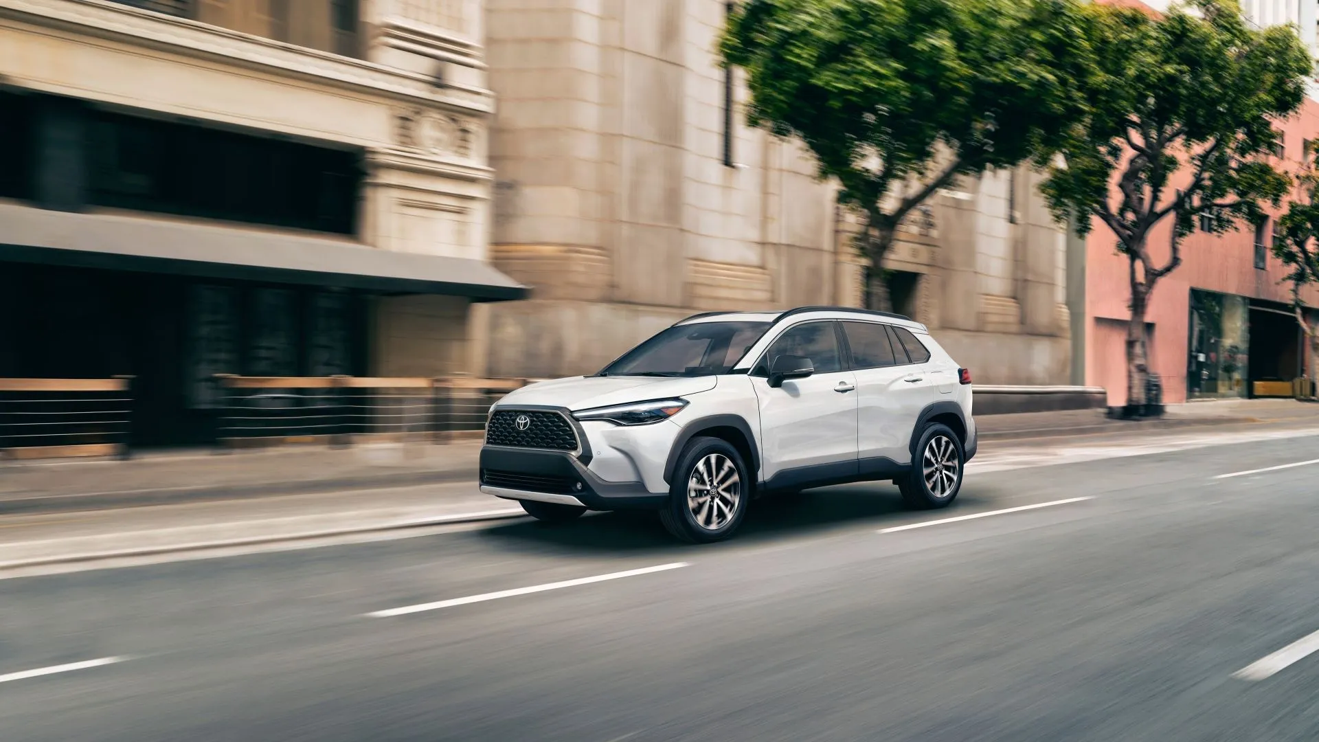 Toyota Corolla Cross 2025 màu xanh bạc hà đang di chuyển trên đường, thể hiện thiết kế phía trước và bên hông
